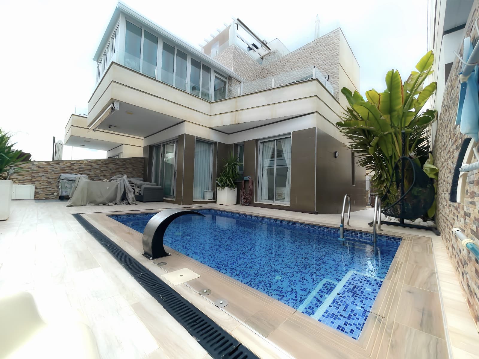 Two-story detached villa with solarium, featuring 3 bedrooms, two bathrooms, and a guest toilet. Private parking space on the property, private pool with integrated spa, and glass-enclosed terrace. Solarium. For sale fully furnished, including a fully equipped kitchen. Located very close to all services within walking distance in Ciudad Quesada.