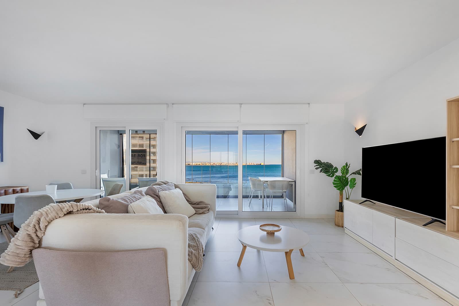 This exclusive 5th-floor apartment is located in the prestigious Posidonia residential complex, on the seafront in Punta Prima. Originally designed with three bedrooms, the property was modified off-plan to offer 94 m² of pure comfort, now distributed into two spacious bedrooms and two bathrooms, gaining exceptional spaciousness in the living areas.Its key strength lies in its double orientation and outdoor spaces: a 16 m² terrace with unobstructed views of the sea and the bay of Torrevieja, and a second 12 m² rear terrace facing south with views towards La Manga, guaranteeing sun, natural light, and cross ventilation throughout the day.The property is sold fully furnished, with an underground parking space and storage room included. The complex features high-standard common areas and security. Located within walking distance of amenities, supermarkets, and coves, it is approximately 45 minutes from Alicante Airport, combining luxury and comfort in one of the most sought-after areas of the Costa Blanca.