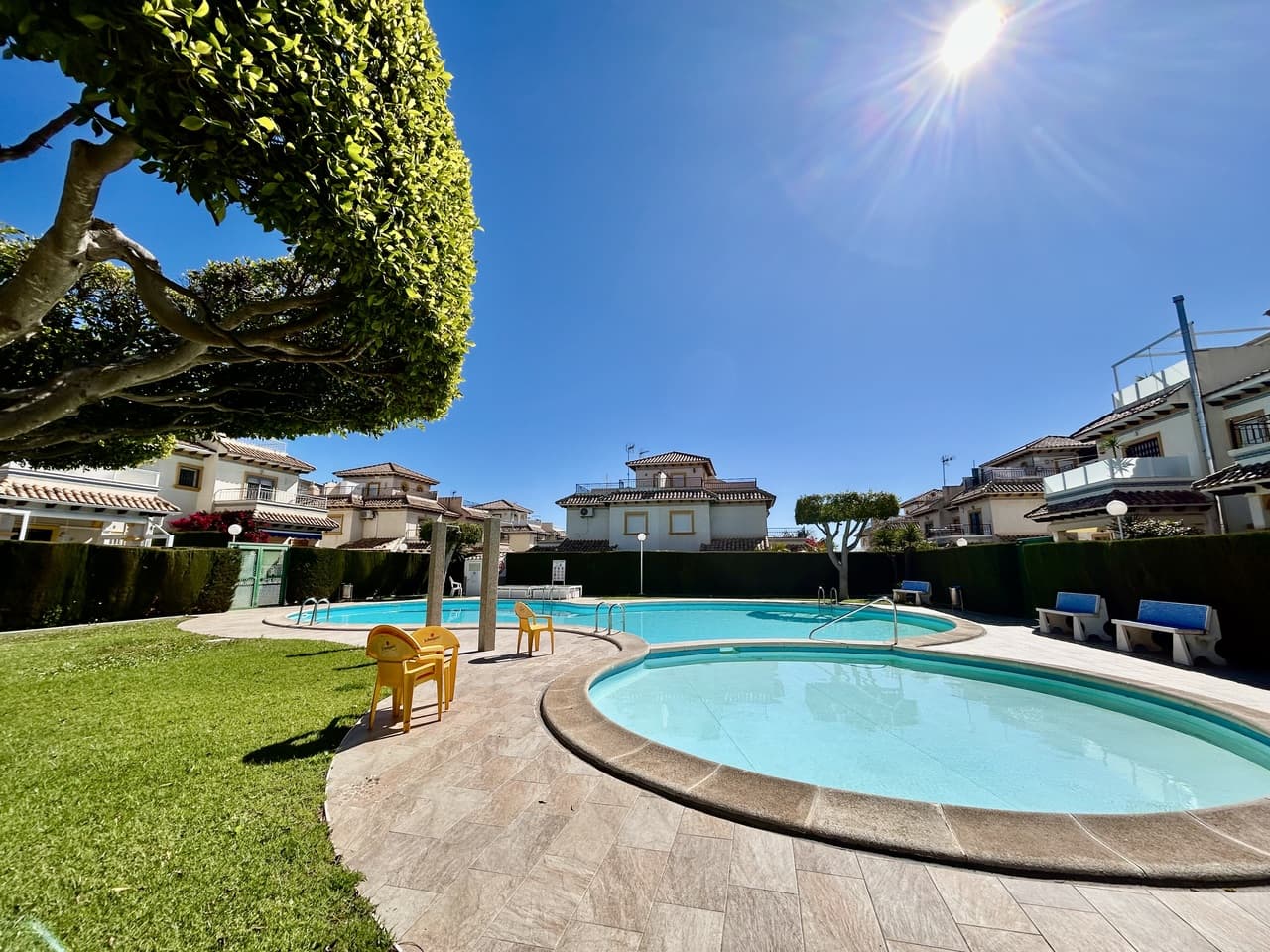 This beautifully presented top-floor apartment in sought-after Punta Prima offers the perfect combination of comfort, outdoor space, and a peaceful setting, making it ideal as a holiday home, rental investment, or permanent residence. Set within a quiet, well-maintained community, residents can enjoy access to a stunning large communal swimming pool, perfect for cooling off on warm summer days or relaxing with family and friends in a tranquil environment. On the ground level, the property benefits from its own private garden and utility area, providing practical storage and a welcoming outdoor space to unwind or entertain.Upstairs, the main living area is bright and inviting, featuring a closed-in conservatory that creates a versatile additional living or dining space for year-round use. From here, you step out onto the south-facing sunny terrace, ideal for enjoying the sun throughout the day and making the most of the Mediterranean climate. The apartment offers two well-proportioned bedrooms and a bathroom, while the enclosed solarium has been cleverly converted into an extra room, perfect as a guest bedroom, home office, or relaxation space.Ideally located, the property is within walking distance of all amenities, including shops, bars, and restaurants, and just a few minutes’ drive from the beach, allowing you to enjoy coastal living at its best.