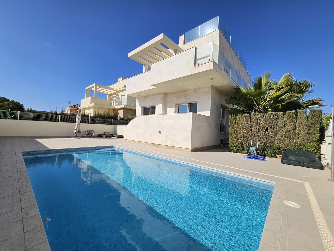 This stunning and modern 5 bedroom, 4 bathrooms detached villa commands a fantastic position in the very popular area of La Zenia, just 100 metres from the beautiful blue flag beach. The area features a huge selection of amenities, including the very impressive Zenia Boulevard shopping centre, with over 150 shops and a selection of good restaurants.Recently built and completed in 2023, this very stylish villa offers spacious rooms throughout, with wonderful outdoor space to enjoy the wonderful Mediterranean climate.The ground floor comprises an entrance hallway, leading into to fabulous living room with a dining area and an open-plan fully fitted kitchen with an island. Large patio doors lead you to the terrace and pool area. This level also features a large double bedroom with ensuite bathroom, a double bedroom and a separate bathroom.An internal staircase leads you to the underbuild, featuring and a separate laundry room.Situated on the first floor is the sumptuous master bedroom with walk-in wardrobe and ensuite, a second large double bedroom with ensuite, and a third guest double bedroom with ensuite. Each bedroom has direct access to the large wrap-around sun terrace.Internal stairs lead to the large roof terrace, perfect for relaxing day or night with views of the sea.The very attractive, low-maintenance garden benefits from the fabulous heated pool, a large terrace area, an outdoor kitchen with a seating area with a retractable awning, a storage room, and a private garage.Other features include Daikin brand air heater with fun-coil, with underfloor heating in all floors.