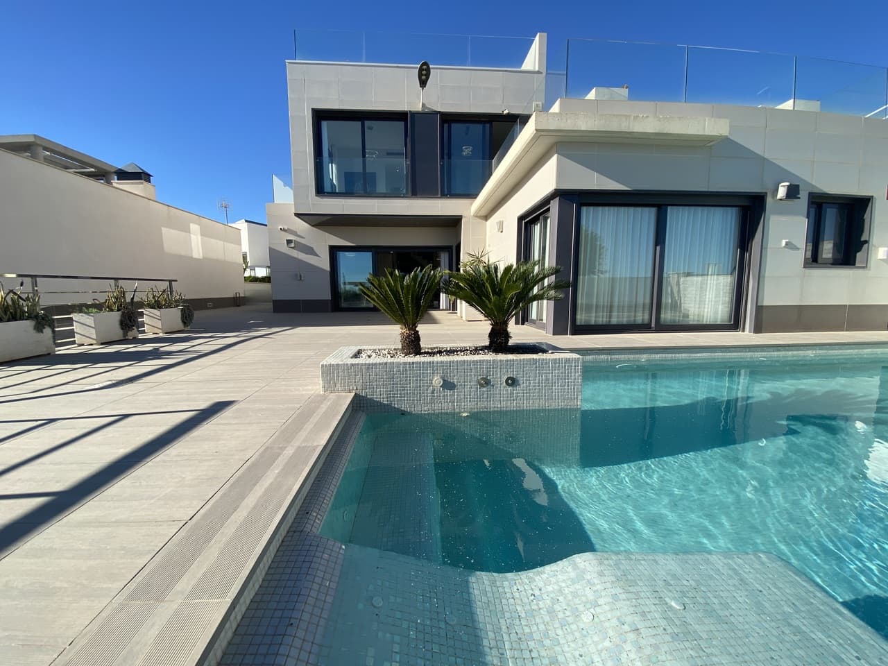 Welcome to this exceptional recently-built luxury villa at Residencial Bellavista, San Miguel de Salinas, offering a harmonious blend of contemporary design and breathtaking views. With a total of 5 bedrooms and 4 bathrooms, this meticulously crafted property spans two floors and a basement, accessible via a convenient elevator and a stunning glass staircase with interior lighting.The basement unfolds into a versatile game room with billiards and table football, a spacious celebration room featuring a full kitchen, 2 bedrooms, 2 storage rooms, and a well-appointed full bathroom. The main floor showcases a seamless living-dining space with an open-concept kitchen and central island, complemented by the main bedroom with an en-suite bathroom. Additionally, a laundry room and a guest toilet enhance the practicality of this level.Ascending to the first floor, you'll discover two generously proportioned bedrooms, two bathrooms, and access to charming balconies. The crowning jewel of this luxury villa is the top-floor 70m² solarium, providing an unparalleled vantage point to savor panoramic views.This property boasts an array of sophisticated features, including air conditioning, a dedicated parking area for multiple vehicles, central heating with underfloor heating throughout, and an elegant furnishing scheme featuring designer furniture. Noteworthy equipment encompasses a pellet machine for heating, solar panels, an electric water heater, security windows and doors, and a comprehensive security system with sensors in every room.The residence is thoughtfully equipped with high-quality amenities such as motorized sofas, brand-new mattresses, a steam oven with pyrolysis, and a combo fridge that dispenses both normal and crushed ice.The outdoor space is a haven of luxury, featuring a private pool with a cascading waterfall, jacuzzi, and hydromassage. The meticulously landscaped poolside area is adorned with lush vegetation, and a convenient outdoor shower adds to the indulgent ambiance. Ample parking within the plot ensures convenience for multiple vehicles.Situated in Residencial Bellavista, just 7 kilometers from the Orihuela beaches, this enclave is surrounded by golf courses and hosts the area's premier shopping center with an array of services, bars, restaurants, shops, and supermarkets. Ideal for nature and tranquility enthusiasts, this residence offers a lifestyle of unparalleled elegance and comfort.