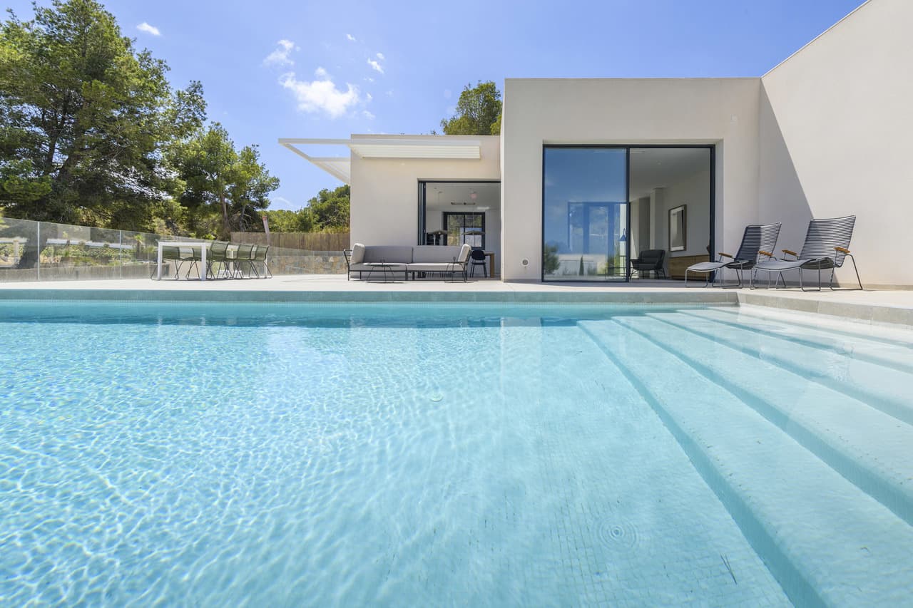 The exclusive frontline golf villas of the Ciruelo Community are located in a privileged location on Las Colinas Golf & Country Club golf course. The Ciruelo Community is made up of different villas, with a carefully studied location to optimise their orientation and views, as well as to ensure the enjoyment of the Mediterranean sun and light. This community has been developed following the Bisbita villa model, which has a large plot of 976 m² with 200 m² of constructed area and a private swimming pool of 40 m². It includes three bedrooms, two bathrooms —an en suite and a guest toilet—, a fully equipped open plan kitchen and a closed garage with two parking spaces.Its one-floor distribution and its large windows maximise its integration into the environment and facilitate outdoor living. Conceived for the enjoyment of the Mediterranean climate and landscape, this exclusive villa is very unique within the residential complex, both for its avant-garde design and its high-quality standards.The project is the work of the architectural studio Abeman Arquitectos.