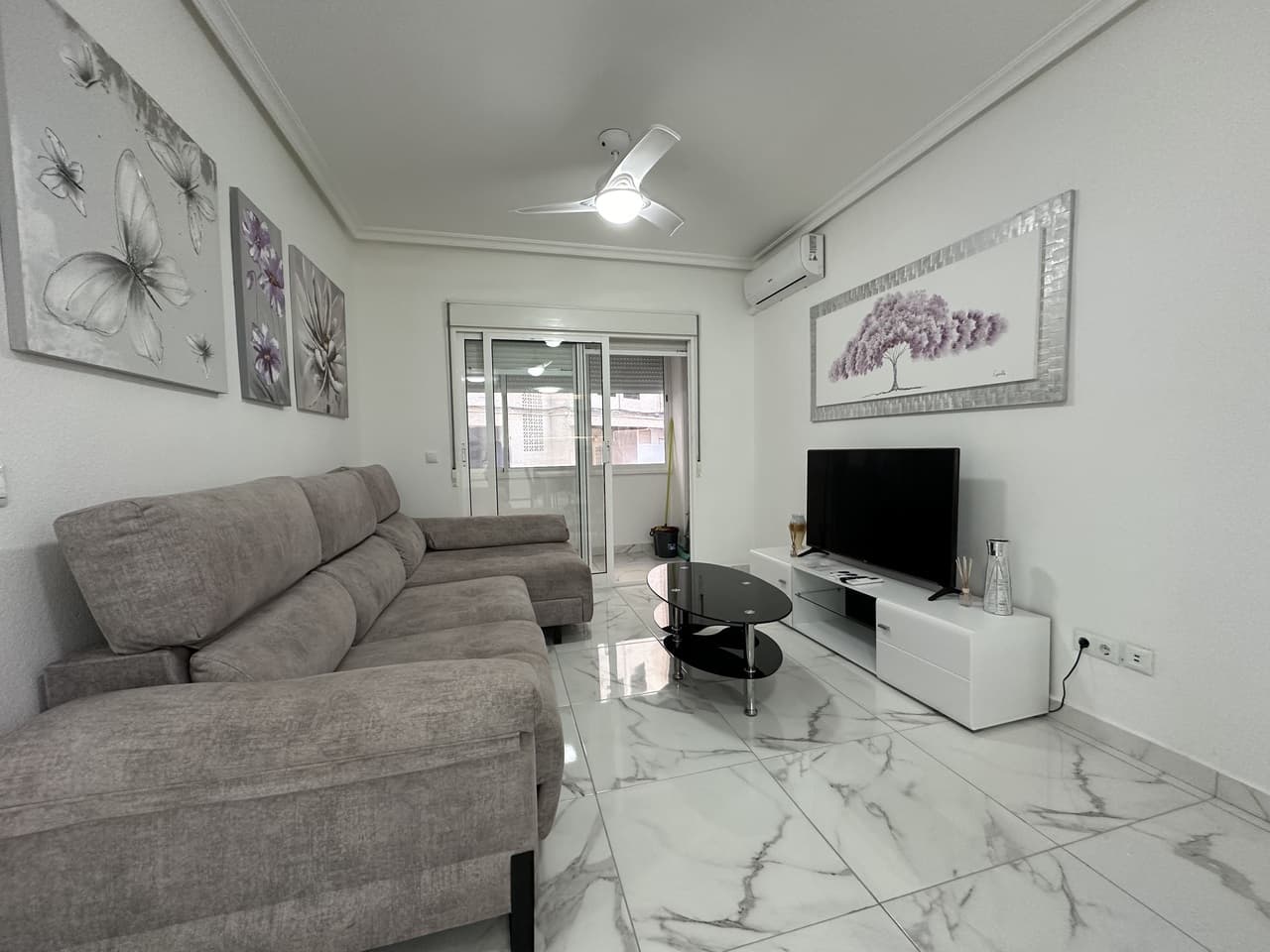 PRIME LOCATION 50m from Playa del Cura, Torrevieja beach is this elevated ground floor apartment. This fabulous 2 bedroom, 2 bathroom apartment has been reformed throughout with a brand new fully equipped kitchen along with 2 stylish bathrooms. The apartment has a huge living and dining room with access to a private glazed terrace with views down to the beach front. The property has two big bedrooms both with fitted wardrobes. The property has been tastefully reformed with modern floor tiling and is sold fully furnished and finished with air-conditioning. The property forms part of a very well maintained private complex where home owners have access to the communal showers and changing rooms to make it easy to wash-off the sand from the beach.