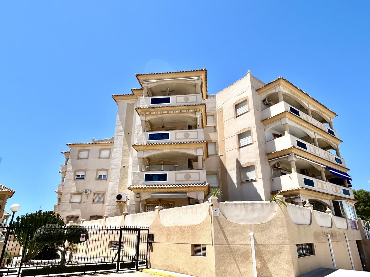 Located in the heart of La Zenia, this 2-bedroom, 1-bathroom apartment offers a blend of traditional style and a central location. The property is situated in a well-maintained building that includes lift access, a communal roof terrace, and a swimming pool. The interior features a functional open-plan layout with air conditioning and traditional character throughout. A private arched balcony provides sea views, while both bedrooms offer outlooks over a neighboring green park area. The apartment is within walking distance of local bars, restaurants, shops, and the beach, and is also conveniently close to La Zenia Boulevard, schools, and medical facilities. For leisure, several championship golf courses are reachable within a ten-minute drive. With easy access to the AP-7, the property is approximately 50 minutes from both Alicante and Murcia airports.
