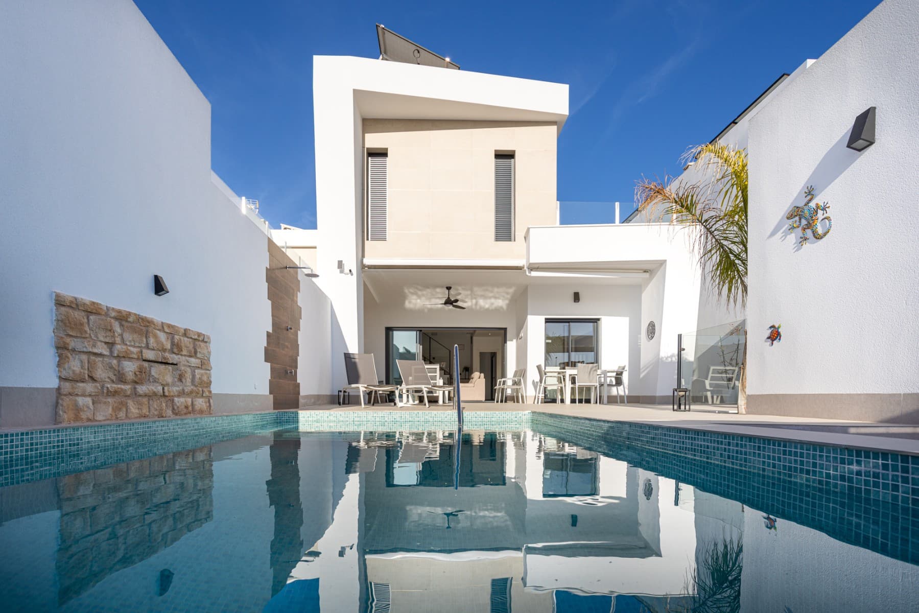 This exceptional almost new detached villa offers a perfect blend of contemporary design, comfort, and investment potential. Set on a 238m² private plot, the property has been thoughtfully designed to maximize space, natural light, and seamless indoor–outdoor living, with a total built area of approximately 150m².Upon entering the villa, you are welcomed into a bright and spacious open-plan living area, where clean architectural lines and large windows create an airy, modern atmosphere. The fully fitted kitchen is elegantly integrated into the space and comes complete with quality electrical appliances, offering both style and practicality—ideal for everyday living or entertaining guests.The main level comprises three generously sized bedrooms, all designed with comfort in mind, along with two contemporary bathrooms finished to a high standard. An additional guest WC adds convenience for visitors.One of the standout features of this property is the expansive basement level, which significantly enhances the living space. This versatile area includes an additional bedroom and offers endless possibilities—whether as a guest suite, home cinema, gym, office, or games room.Step outside to your own private oasis, where a 6x3 metre swimming pool takes centre stage, surrounded by ample terrace space for sunbathing, dining, and relaxing in complete privacy. The outdoor area has been designed for low maintenance while still providing an inviting environment for enjoying the Mediterranean lifestyle. The property also benefits from secure parking within the plot.This villa is equipped with a range of modern features to ensure maximum comfort and energy efficiency, including ducted air conditioning throughout, electric blinds, and a solar panel system (12 panels) to reduce energy costs and environmental impact.Offered fully furnished, the property is ready for immediate occupation or rental. Importantly, it also includes a valid tourist licence, making it a highly attractive opportunity for those seeking a turnkey investment with strong rental potential.Combining sleek modern living with practical features and excellent income prospects, this villa represents a rare opportunity to acquire a move-in-ready home in pristine condition.