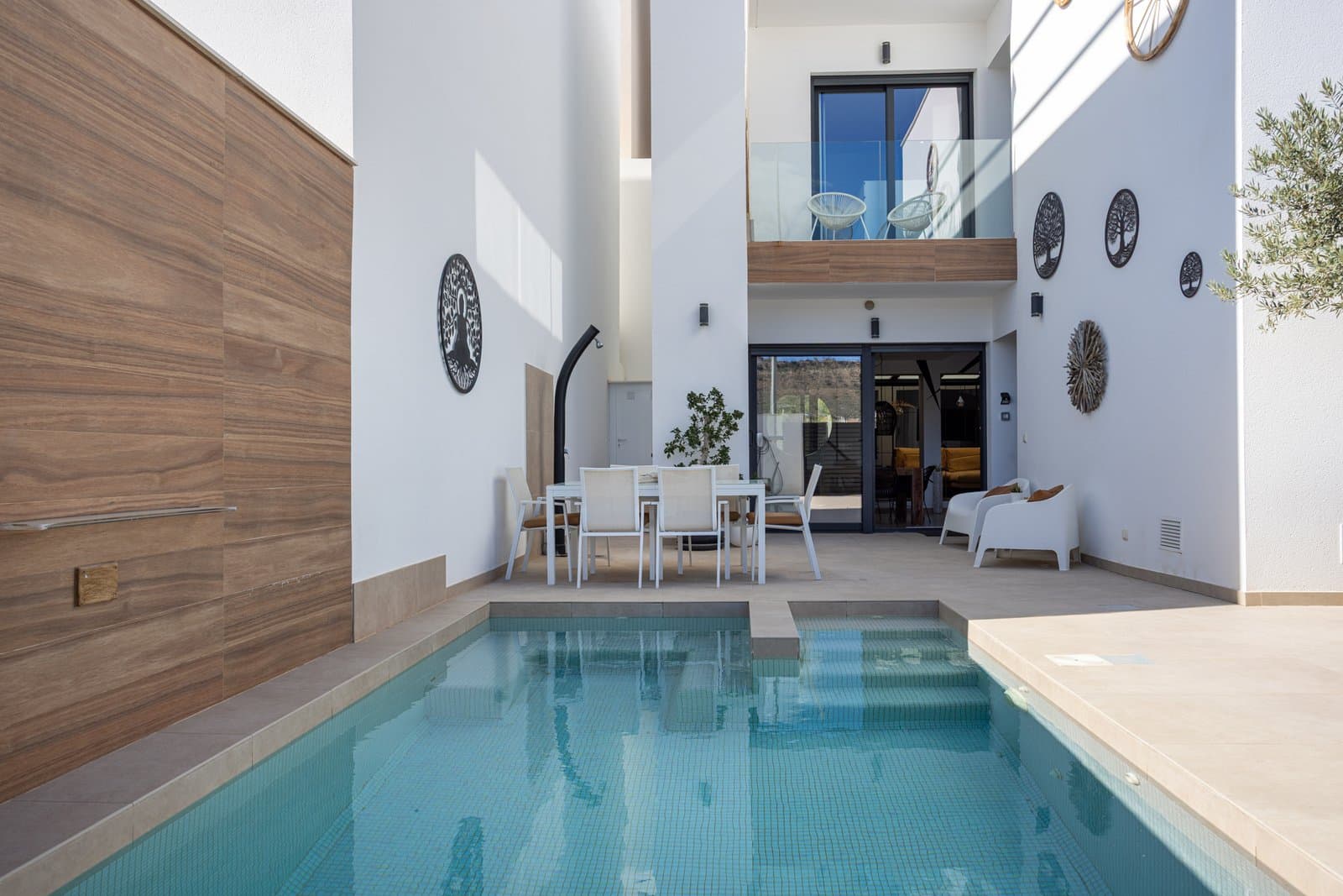 Located in the charming and highly sought-after village of Benijófar, one of the fastest growing and most desirable areas on the Costa Blanca, this stunning modern townhouse built in 2018 offers an exceptional combination of contemporary design, comfort and an enviable location. Perfectly positioned overlooking a beautiful green park area, the property enjoys open, uninterrupted views, as no construction is permitted in front, ensuring lasting privacy, tranquility and a pleasant natural outlook.Despite its peaceful setting, the property is just a short walk from the centre of Benijófar, where you will find a wide selection of restaurants, cafés, shops, supermarkets and everyday amenities. The area is well known for its welcoming atmosphere, traditional Spanish charm and excellent connection to nearby beaches, golf courses and larger towns along the coast.Modern Design and Comfortable LivingThe property has been designed with modern living in mind, offering bright and spacious interiors with a practical and elegant layout. The main living area features a stylish open-plan design, combining the living room, dining area and fully equipped modern kitchen into one harmonious space. Large windows allow abundant natural light to fill the home while also creating a seamless connection with the outdoor areas. From the living room you have direct access to the private terrace and swimming pool, providing the perfect setting for relaxing, entertaining guests or enjoying outdoor dining in the Mediterranean climate.The private swimming pool is heated with a heat pump, allowing comfortable use throughout much of the year.Spacious Bedrooms with En-Suite BathroomsThe townhouse offers three generous bedrooms, each designed for comfort and privacy, and three modern en-suite bathrooms. Currently, one of the rooms is used as a walk-in dressing room and another as a home office, but both can easily be converted back into bedrooms if desired. This flexibility makes the property ideal for families, remote working or accommodating guests.Impressive Rooftop SolariumOne of the standout features of this home is the spacious rooftop solarium, where you can enjoy panoramic views of the surrounding area and the green park in front of the property. This elevated outdoor space is perfect for sunbathing, relaxing with friends, or creating a chill-out area to fully appreciate the Costa Blanca lifestyle.Sustainable and Future-ReadyThe property has also been designed with energy efficiency and sustainability in mind. It is equipped with solar panels, helping to reduce energy consumption, as well as an electric vehicle charging point, making it a forward-thinking and environmentally conscious home.Additional Features This beautiful townhouse benefits from a number of additional features that further enhance comfort and practicality, including:Private heated swimming pool, Solar panel energy system, Electric vehicle charging point, Large rooftop solarium with open views, Ample storage space, Modern high-quality finishes throughout, Sold fully furnished, allowing immediate occupation Ready to Move Into Presented in excellent condition and meticulously maintained, this property is truly turnkey. Everything has been carefully designed to offer both style and functionality, allowing the new owners to simply move in and begin enjoying life under the Spanish sun. Whether you are searching for a permanent residence, a luxury holiday home, or a smart investment opportunity, this outstanding townhouse in Benijófar represents a rare opportunity to acquire a modern property in one of the most attractive and vibrant areas of the Costa Blanca.