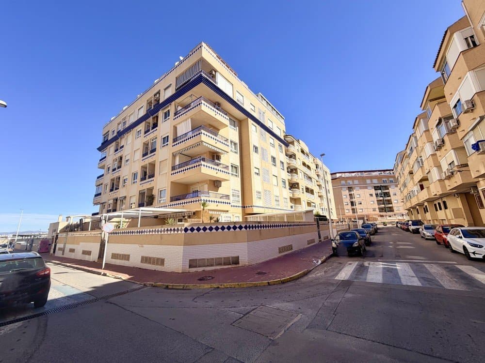 This well-presented first-floor apartment is ideally located in the highly sought-after area of Guardamar del Segura, just a short stroll from the port, a wide selection of shops, and the beautiful sandy beaches.The property is situated within a well-maintained building offering the convenience of two elevators, ensuring easy access at all times. Inside, the apartment features two spacious bedrooms, including a generous master bedroom complete with an en-suite bathroom and a large built-in wardrobe. A second full bathroom with a bathtub serves the rest of the property. Both bathrooms benefit from natural light and ventilation thanks to their exterior windows.The living accommodation includes a bright and comfortable lounge of good size, with direct access to a private balcony perfect for relaxing or enjoying the Mediterranean climate. The separate kitchen is fully functional and also offers access to the same balcony, enhancing both practicality and outdoor living.The surrounding area is truly exceptional. Just a few steps away, you will find the beautiful pine forest (pinada), offering a peaceful natural environment ideal for walking, cycling, or simply unwinding. Combined with the proximity to the port, beach, and local amenities, this apartment represents an excellent opportunity for both permanent living and holiday use.