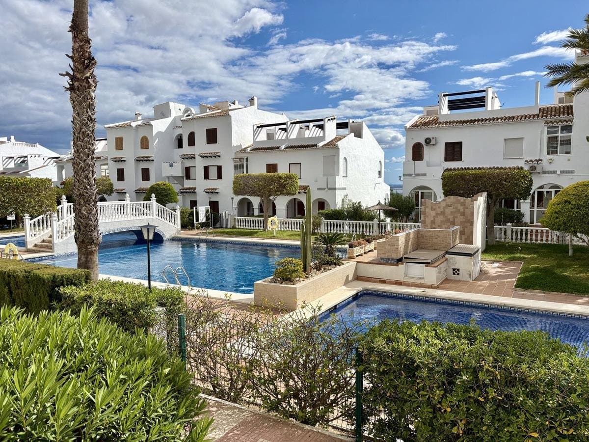 Discover a unique property located in the prestigious Bravo Hills Club development, one of the most sought-after residential areas in Ciudad Quesada. Positioned at the highest point of the hill, this home enjoys stunning panoramic views stretching across the Mediterranean Sea, nearby lagoons, and the surrounding mountains—an exceptional setting that is hard to match.Bravo Hills Club is a gated residential community known for its location and well-maintained environment, offering a stable and established neighbourhood. Unlike busier coastal areas, the development benefits from low tourist turnover, making it an ideal choice both as a permanent residence and as a second home.Residents have access to excellent communal facilities, including a private parking area with automated entry, beautifully maintained gardens, a large communal swimming pool alongside a separate children’s pool, as well as charming relaxation areas with fountains. The community is currently undergoing a full façade renovation, and this property has already been completed, representing added value with no extra cost for the future owner.Property FeaturesThe home benefits from two independent entrances: one from the street via a private, fully fenced garden, and another from the communal area with direct access to the pool.Its dual orientation (north-east and south-west) ensures abundant natural light throughout the day, as well as excellent cross-ventilation. Even during the warmer months, the property remains comfortable, although it is also equipped with air conditioning with heating function for year-round comfort.The large windows have been upgraded with modern, energy-efficient and sound-insulated frames, complete with shutters, significantly enhancing overall comfort.Layout · Ground floor: spacious living room, kitchen, guest toilet, two terraces and private garden · First floor: two bedrooms (one with sea views), full bathroom with bathtub, walk-in wardrobe and terrace · Solarium: partially enclosed, featuring an additional glazed room that can be used as an extra bedroom, office or leisure space, with open views towards Alicante and the surrounding mountainsAll three terraces offer potential for enclosure, allowing for an increase in the usable living space.Condition and EquipmentThe property is sold fully furnished, with approximately half of the furniture being almost new. Several appliances have also been recently replaced, including the refrigerator.The home is ready to move into, although the bathrooms would benefit from modernisation, offering the opportunity to personalise them according to the new owner’s preferences and further increase the property’s value.Location and SurroundingsThe property enjoys a convenient location with all essential services within easy reach: · Shops, restaurants and car rental services approximately 10 minutes’ walk · Beaches of Guardamar del Segura around 15 minutes by car · Alicante Airport approximately 35 minutes by carThe area has a well-established international community, making everyday life comfortable even without knowledge of Spanish!!