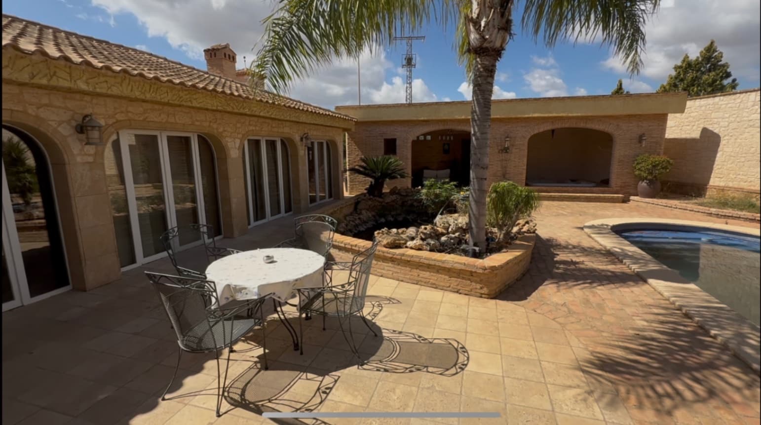 Welcome to a one-of-a-kind luxury estate, nestled on a vast 4,000+ square meter plot in the peaceful countryside, where tranquility is absolute and the only sounds you’ll hear are the songs of birds. This stunning property offers a rare combination of refined rustic elegance, modern comfort, and unmatched outdoor beauty – the perfect retreat for those seeking space, privacy, and connection with nature.MAIN HOUSE: This tastefully designed rustic home boasts 3 spacious bedrooms and 3 full bathrooms, each with high-quality finishes that complement the overall charm of the estate. The master bedroom features its own private indoor jacuzzi, turning your personal suite into a spa-like haven Central heating and cooling are provided through an efficient vent system, ensuring comfort all year round.GUEST HOUSE: Ideal for visitors or extended family, the guest house offers 2 additional bedrooms and 2 bathrooms. Like the main residence, it reflects the same architectural style and comfort standards, allowing guests to enjoy their own private space with ease.OUTDOOR LIVING:The outdoor areas of the property are truly exceptional. A large, crystal-clear pool serves as the centerpiece of the garden, surrounded by sun loungers, lush landscaping, and uninterrupted views of the Campo. An inviting jacuzzi sits nearby complemented by a sauna,ideal for evening relaxation under the stars.An artificial river gracefully winds its way across the property, adding to the tranquil ambiance and giving the estate a peaceful, park-like setting.STORAGE & GARAGE:A private 2-car garage provides secure parking, while an additional spacious storage room doubles as a utility building with machinery. It’s large enough to accommodate an additional 4 to 5 vehicles depending on size—ideal for collectors, enthusiasts, or practical storage.WINERY AND CELLAR: discover your very own private winery, a charming and authentic space perfect for storing and showcasing your wine collection or entertaining guests with tastings in an atmospheric setting.FARM AND AVIERY: For those with a love of country life, the property features a delightful mini farm area, complete with chickens and a dedicated bird enclosure. It’s a lovely touch that adds character and sustainability to this already unique estate.DESIGN AND CONSTRUCTION :The entire property has been crafted with precision and care. Every beam, stone, and tile has been selected to match the rustic aesthetic, creating a cohesive and timeless design throughout. The home strikes a perfect balance between tradition and modern luxury, making it not just a residence, but a lifestyle.