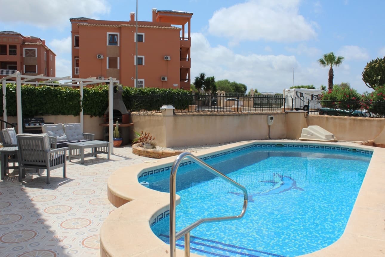 This beautifully 2 bedroom ground floor apartment with private garden and swimming pool is located in Sol Golf I - Pau 8, Villamartin. Just a short walk to the famous Villamartin Plaza and golf course. The apartment features a spacious 143m2 tiled garden with a private 10x5m swimming pool, BBQ and a covered terrace with glass curtains, offering an ideal space for year-round outdoor living. Inside, the property offers a bright and inviting lounge with feature fireplace, leading through to a modernised kitchen with separate utility room and shower room, along with direct access to the garden and an electric blind for added comfort. A small hallway leads to two double bedrooms, both with fitted wardrobes, and a contemporary family bathroom with walk-in shower. Additional features include air conditioning, high-speed fibre optic internet (FTTH) – ideal for remote working – and is being sold furnished, including white goods. Sol Golf I enjoys a prime location at the entrance of Pau 8 with a communal swimming pool, public transport is easily accessible, with a bus stop and taxi rank nearby and within 10 min walking distance to all amenities, supermarkets and to the popular Villamartin Plaza with lots of restaurants and bars, bank only a 10 min drive to the beautiful sandy beaches of Orihuela Costa, and 5 min to La Zenia Boulevard the largest Shopping centre in the Alicante province with over 150 shops plus restaurants and bars. For golf enthusiasts there are 4 local Golf Courses; Villamartin, Las Ramblas, Campoamor and Las Colinas. Alicante airport and Corvera airport in Murcia are about 45 minutes drive away.