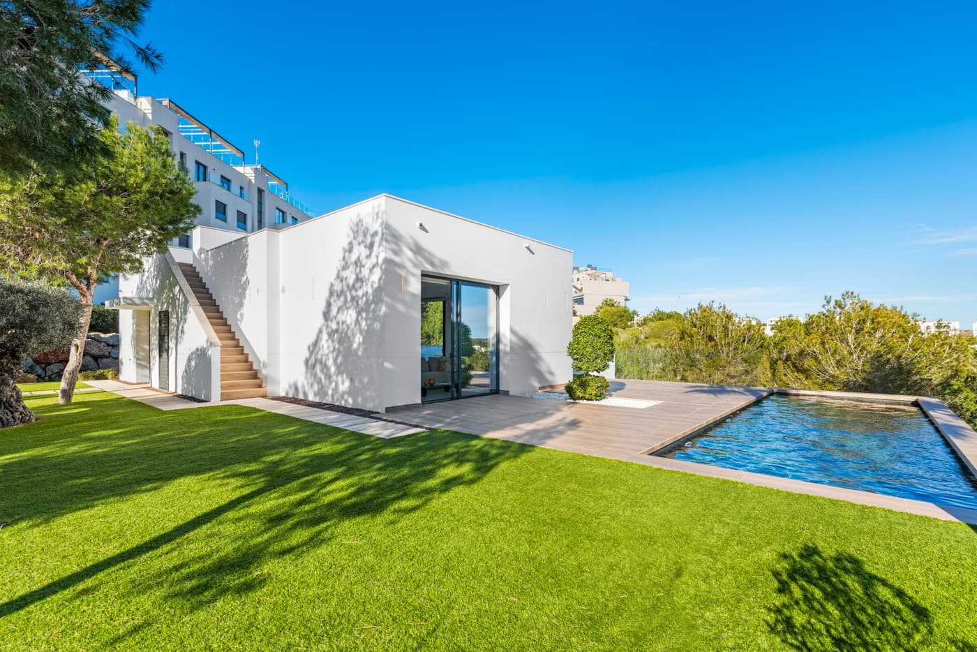 Nestled within the prestigious Las Colinas Golf & Country Club, one of the most exclusive golf resorts on the Costa Blanca, this breathtaking villa offers a unique blend of luxury, comfort, and nature. With its refined architecture and high-end finishes, this home provides everything you need for a carefree and stylish life under the Spanish sun.

Upon entering, you are welcomed into a spacious and bright living area, where large windows offer stunning views of the surrounding landscape. The open-plan kitchen, fully equipped with modern built-in appliances, serves as the heart of the home and seamlessly flows into the elegant living room. Here, you can relax and enjoy cozy evenings in an atmosphere of pure sophistication.

The villa features four generously sized bedrooms, including a master suite on the ground floor with its own en-suite bathroom, providing extra privacy and convenience. Additionally, there is a separate guest toilet on this level.

On the lower floor, you will find three more spacious bedrooms, all with breathtaking views of the natural garden. Large windows allow natural light to flood the space, bringing the outdoors inside. This floor also houses two stylish bathrooms and a separate laundry room, combining practicality with modern elegance.

The outdoor spaces are just as impressive as the interior. The beautifully landscaped garden offers a tranquil oasis where you can unwind, surrounded by the natural beauty of the resort. The heated private pool invites you for a refreshing dip at any time of the day, while the spacious terraces provide the perfect setting for long summer evenings of relaxation and entertainment.

This villa is equipped with the latest technology, including an advanced home automation system, allowing you to effortlessly control lighting, temperature, and security. The Airzone climate system ensures perfect indoor comfort in every room, while the automatic shutters provide additional convenience and privacy. Additionally, solar panels contribute to an energy-efficient and sustainable living experience.

For your convenience, the property offers private parking for two cars, ensuring a secure and comfortable place for your vehicles. Moreover, this exclusive villa comes fully furnished with luxury furniture worth €30,000 – everything is meticulously designed and ready for you to move in.

Living in Las Colinas Golf & Country Club means embracing an exceptional lifestyle. This exclusive resort not only boasts an award-winning golf course but also offers a range of luxury amenities, including sports facilities, fine dining restaurants, and a secure residential environment. Furthermore, the stunning sandy beaches of the Costa Blanca are just a short drive away.

Are you looking for a dream home where luxury, nature, and exclusivity come together? Then this villa in Las Colinas is the perfect choice. Contact us today for a viewing and experience this extraordinary living opportunity.