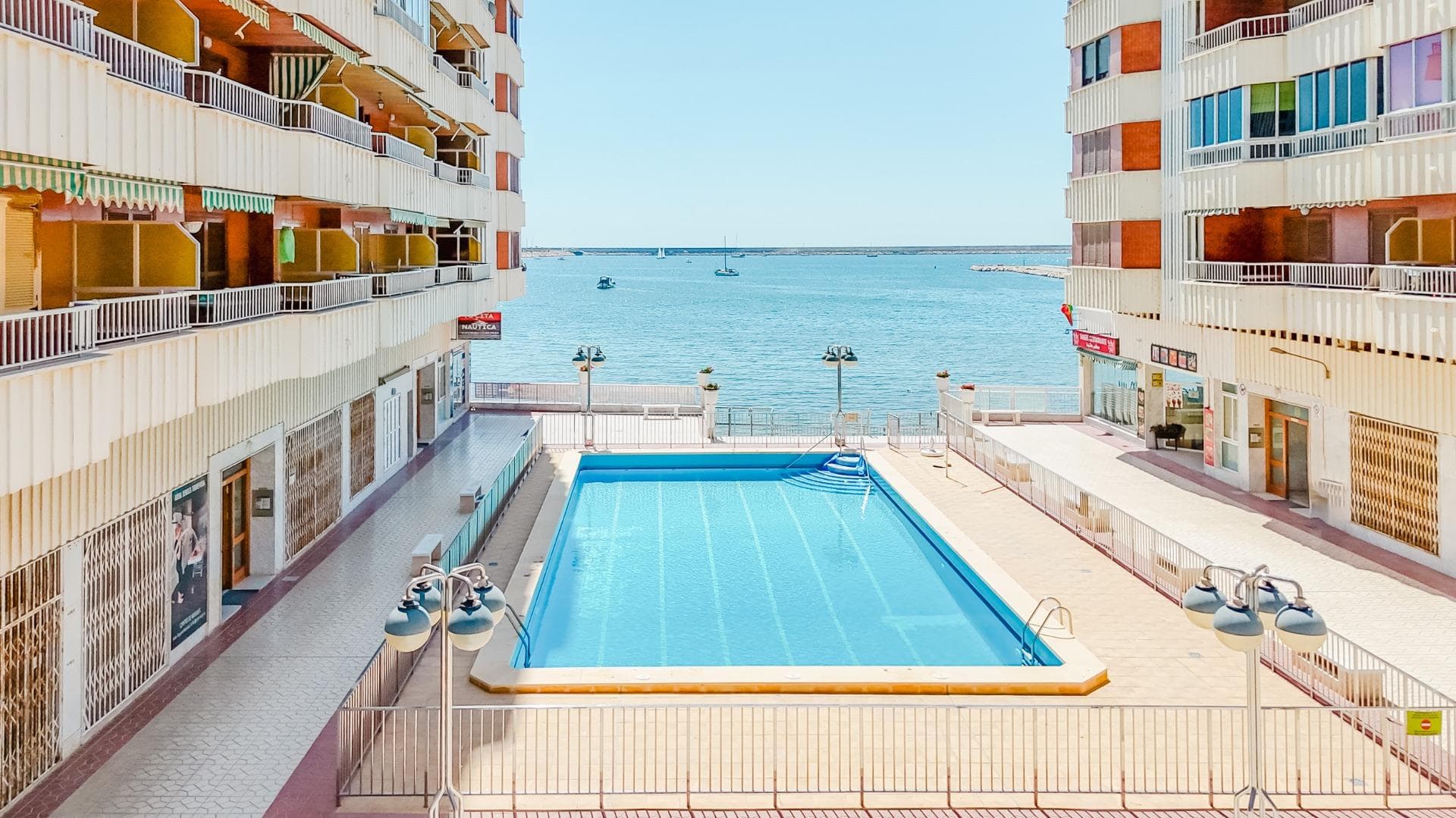 Se vende ático de 3 dormitorios en la décima planta de una torre de 10 plantas con vistas al mar Mediterráneo y a la Laguna Rosa de Torrevieja. El apartamento se encuentra en Torrevieja, provincia de Alicante, en la avenida Gregorio Marañón, en el complejo de torres "Novomares", en primera línea de mar y de la playa del Acequión. El complejo es un condominio con piscina y acceso directo a la playa. El apartamento ha sido completamente reformado: todo es nuevo — suelos, marcos de ventanas, cocina, fontanería, tuberías y desagües. El salón ha sido ampliado incorporando el balcón, ofreciendo ahora vistas panorámicas a la ciudad y al mar enmarcadas por bonitos marcos de PVC. Superficie útil — 110 m². La vivienda consta de recibidor y pasillo que da acceso a una cocina independiente totalmente equipada con zona de lavandería. Desde el pasillo también se accede a un baño, un amplio salón de 38 m² y tres dormitorios independientes con armarios empotrados. El dormitorio principal tiene salida a un gran baño con ducha y sanitarios modernos. Se vende con cocina y baños equipados, aire acondicionado e iluminación... pero sin muebles.