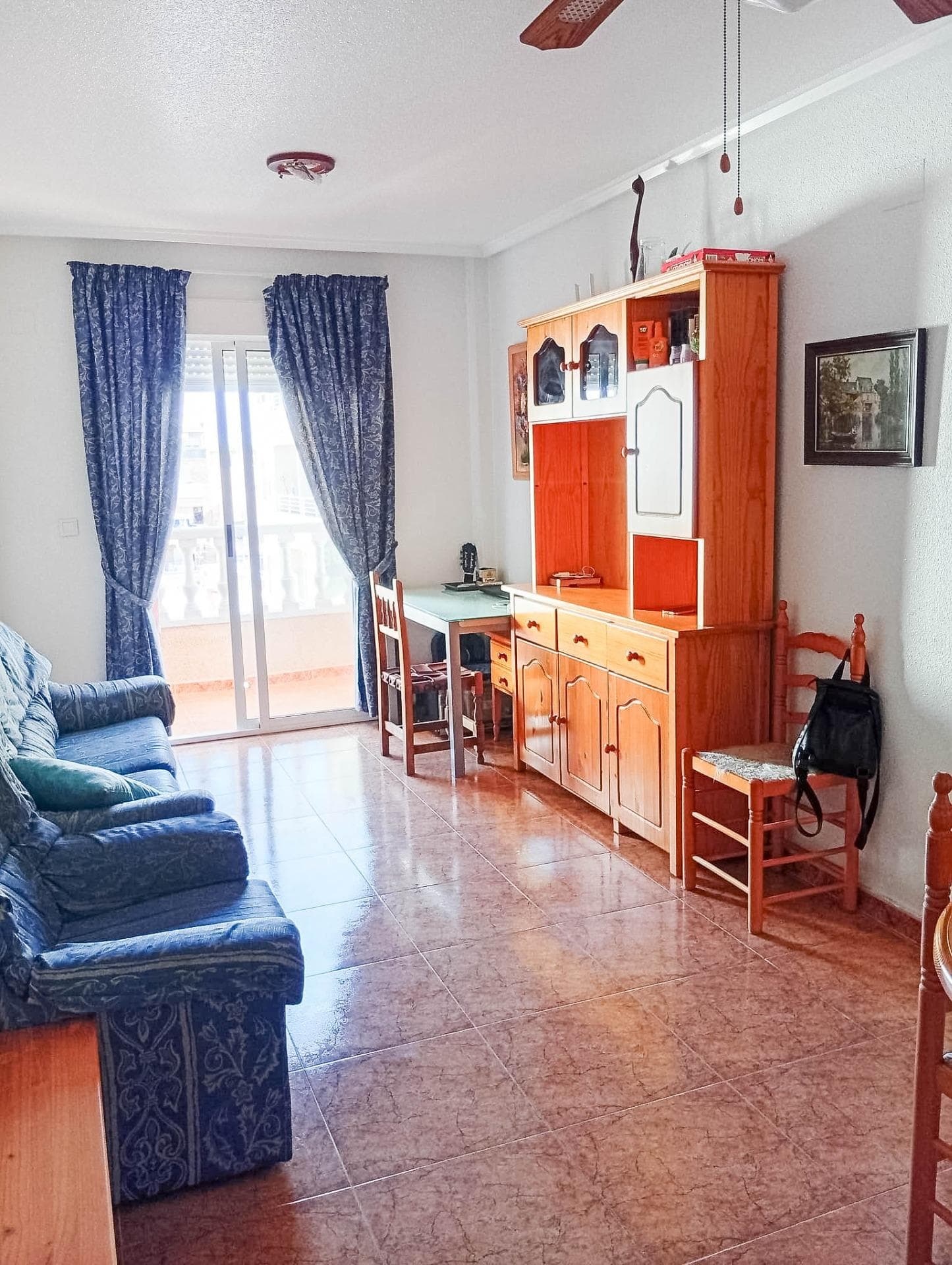 For sale: 2-bedroom apartment with a full bathroom, located on a sunny 4th floor with south-east orientation, with lift, on Calle Los Molinos 9, in the centre of Torrevieja (Building “Velázquez 7”). Quiet area next to Calvario Park, Consum supermarket, bus routes and a school. The apartment has 70 m² total and 53 m² living space, and consists of a small entrance hall, living room with open American-style kitchen and access to the oval balcony, two separate bedrooms with built-in wardrobes and a full bathroom. The master bedroom also has access to the same oval balcony. The apartment is sold fully furnished, with household appliances and air conditioning.