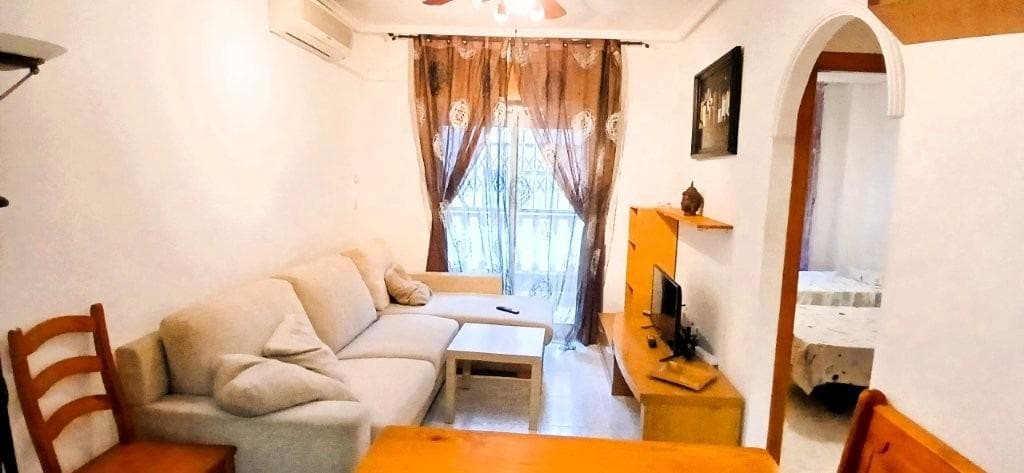 Ubicado en una de las zonas más demandadas de Torrevieja, entre Playa del Cura, Playa de Los Locos y la famosa Curva del Palangre, este encantador apartamento en planta baja es la oportunidad perfecta tanto para vivir todo el año como para disfrutar de unas vacaciones junto al mar. Con todos los servicios a pie de calle – supermercados como Consum, parada de autobús, la sala de fiestas Seraton y una gran variedad de comercios y restaurantes – este inmueble ofrece comodidad, accesibilidad y calidad de vida. Características principales: 🛏 2 dormitorios amplios y luminosos 🛋 Salón comedor acogedor, ideal para relajarse en familia 🍽 Cocina equipada con espacio funcional 🛁 Baño completo ❄️ Aire acondicionado instalado 🌿 Terraza privada y patio interior 🏊 Piscina comunitaria para disfrutar en verano 🪑 Se vende amueblado, listo para entrar a vivir Gastos: Suma: 161,82€/año Comunidad: 421€/año Su estratégica ubicación y las excelentes prestaciones lo convierten en una opción ideal para quienes buscan tranquilidad sin renunciar a estar cerca del mar y todos los servicios.
