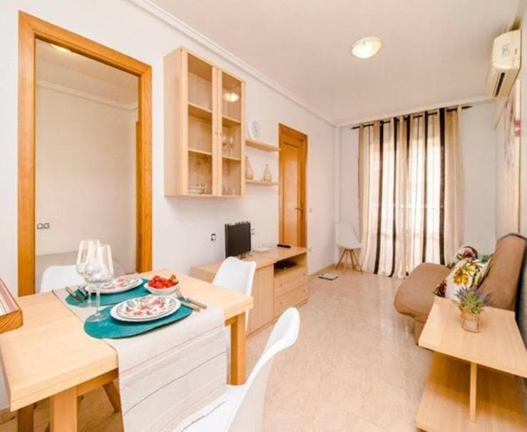 Os presento este precioso apartamento en centro de Torrevieja. Se encuentra a tan solo 600m de la playa.  El apartamento ofrece una superficie construida de 60.70m2, distribuido en la cuarta planta. Tiene un amplio salón-comedor con acceso directo a la terraza con unas preciosas vistas a la piscina. Tiene una cocina independiente totalmente equipada con mubles y electrodomésticos. Cuenta con 2 dormitorios y 1 baño.  Se encuentra en una urbanización que dispone de ascensor. Tiene piscina comunitaria. Su ubicación es ideal, con todos los servicios a tu alcance: supermercados, colegios, tiendas, bancos y restaurantes. Todas las comodidades para ofrecerte una calidad de vida inigualable en una de las zonas más buscadas de la Costa Blanca. ! No esperes más ven a visitarlo!