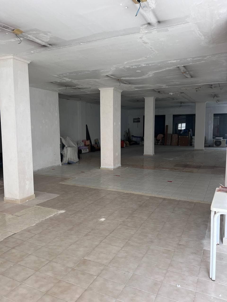 A spacious commercial property of 247 m² with high ceilings (2.90 m), located on a busy street between two popular beaches. This unique space offers great potential for both business or residential purposes. Preliminary permission has already been granted to divide the space into two apartments, with the possibility to create up to three. The property features two separate entrances, three large front-facing windows, and three more windows facing the garden, filling the space with plenty of natural light and air. The open and flexible layout allows for a variety of uses. Additionally, there is a small but charming garden where a fig tree grows, making it an ideal spot for outdoor dining or creating a cozy relaxation area.