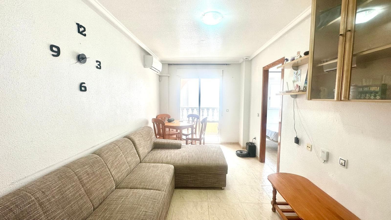 Third Floor Apartment 450 Meters from the Beach – Space, Comfort, and Services Within Reach We present this bright third-floor apartment, located just 450 meters from the beach and one block from the Torrevieja bus station. Its strategic location in the center places you surrounded by all services: supermarkets, pharmacies, restaurants, schools, and public transportation. Layout and Rooms Bedrooms: 2 double bedrooms, both with exterior windows that guarantee natural light and ventilation. Bathroom: 1 full bathroom, equipped with a shower and modern furniture to maximize the space. Kitchen: Independent and fully equipped with top-brand appliances, large countertops, and high and low cabinets for ample storage. Living-dining room: Spacious and open-plan, with air conditioning installed, which, together with the climate control system in the main room, ensures a comfortable microclimate year-round. Terrace and Common Areas South-facing terrace: Spacious and sunny, it receives natural light all day, making it the perfect place for breakfast, reading, or dining al fresco. Communal pool: Ideal for cooling off in the summer and socializing with neighbors in a well-maintained and safe environment. Highlights 3rd floor with elevator Air conditioning in the living room and master bedroom Immediate proximity to the bus station 450m from the beach, accessible in a few minutes on foot This apartment combines location, brightness, and comfort, making it an excellent option both as a permanent residence and as a holiday investment. Want more information or to schedule a viewing? Contact us without obligation.
