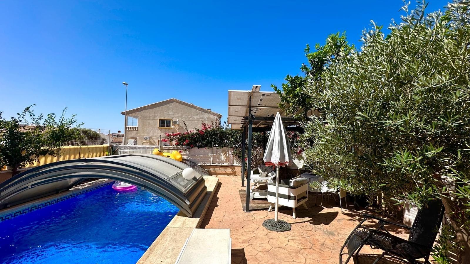 Chalet Independiente en Esquina con Piscina Propia y Solárium – A tan solo 1 km del mar Te presentamos esta magnífica propiedad situada en una exclusiva urbanización residencial a tan solo un kilómetro de la costa. Se trata de un chalet independiente en esquina que ofrece privacidad, confort y una excelente calidad de vida tanto para residencia habitual como para segunda vivienda cerca del mar. Distribución y espacios exteriores Con una parcela de 200 m² y 119 m² construidos, esta vivienda se distribuye en tres plantas que maximizan el espacio y la funcionalidad. La propiedad cuenta con acceso para vehículo y aparcamiento dentro de la parcela, así como con su propia piscina privada, todo rodeado por un jardín bien mantenido y zonas de terraza ideales para disfrutar del aire libre. Además, forma parte de una urbanización que ofrece también piscina comunitaria, brindando más opciones de ocio sin salir del entorno. Primera planta: zonas comunes y confort Al acceder a la vivienda nos recibe un hall acristalado que aporta luminosidad y amplitud desde el primer momento. En esta planta se encuentra un moderno cuarto de baño completo, una cocina independiente de diseño actual, completamente equipada con electrodomésticos de calidad, una despensa adicional y un salón comedor amplio y luminoso. Desde el salón se accede a una terraza acristalada con vistas directas a la piscina privada y al jardín, creando un ambiente perfecto para reuniones familiares o momentos de relax. Segunda planta: zona de descanso En la planta superior encontramos tres habitaciones dobles, todas con armarios empotrados. La habitación principal cuenta con su propio cuarto de baño en suite, garantizando intimidad y comodidad. Además, hay un segundo baño completo que da servicio al resto de habitaciones. Tercera planta: solárium y trastero La tercera planta alberga un práctico trastero y un amplio solárium privado, ideal para tomar el sol, colocar una zona chill-out o incluso un pequeño huerto urbano. Desde aquí se pueden disfrutar de vistas despejadas y un entorno tranquilo. Extras y eficiencia energética La vivienda está equipada con aire acondicionado en todas las estancias para asegurar el máximo confort durante todo el año. Además, dispone de placas solares ya instaladas, lo que contribuye a un consumo energético más eficiente, reduciendo significativamente los costes eléctricos y promoviendo un estilo de vida más sostenible. Resumen de características: Chalet independiente en esquina Parcela de 200 m² 119 m² construidos Piscina privada y piscina comunitaria 3 plantas 3 habitaciones con armarios empotrados 3 baños (1 en suite) Cocina independiente equipada Salón comedor + terraza acristalada Trastero y solárium privado Aire acondicionado en todas las estancias Placas solares para autoconsumo Parking dentro de la parcela A solo 1 km del mar Una vivienda perfecta para quienes buscan espacio, privacidad y un entorno tranquilo con todos los servicios cerca y el mar a solo unos minutos. ¿Te gustaría agendar una visita o recibir más información? Estamos a tu disposición.