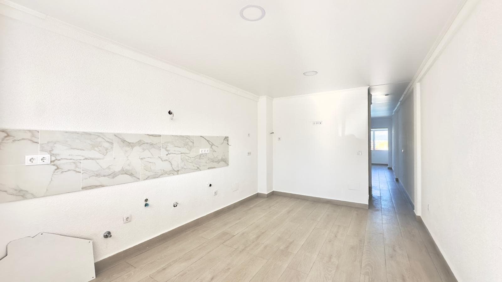 This three-story townhouse with a basement on Avenida Torreblanca is designed as a home with its own unique character. The spaciousness, natural light, and varying ceiling heights allow you to envision a comfortable and versatile lifestyle in one of Torrevieja's most sought-after residential areas. Its location within a gated community with a communal swimming pool and its proximity to La Mata beach further enhance its appeal as a home where you can combine relaxation, daily routines, and Mediterranean leisure activities year-round. Environment and Lifestyle in Torreblanca The Torreblanca area has established itself as a highly desirable residential location, situated between the town center of Torrevieja and La Mata beach. It offers a peaceful yet well-connected environment. Wide streets, townhouses, residential complexes with communal areas, and nearby amenities create a comfortable daily life for those seeking to live close to the sea without being in the heart of the city.  The surroundings are ideal for walking, outdoor sports, and enjoying open spaces, with routes leading to the coast, the Torre del Moro (Moorish Tower), and viewpoints overlooking the Mediterranean. The mix of permanent residents and owners who use their property as a second home creates a diverse atmosphere, while maintaining a strong sense of neighborhood and community.  Location and Connections Avenida Torreblanca is one of the main thoroughfares in this area, providing quick access to the N-332 highway and connections to Torrevieja town center, La Mata, Orihuela Costa, and Alicante. Nearby, you'll find bus stops, small shopping centers, supermarkets, and restaurants, so everyday needs can be met within easy reach of the property. This location also makes it easy for family and friends to visit, making it a popular meeting place, whether for holidays, weekends, or longer stays. The proximity to La Mata beach adds an extra layer of appeal, allowing you to integrate the sea into your daily routine without needing a car. Three-story house concept The townhouse is organized on three main levels plus a basement, resulting in a vertical structure where each floor can serve a distinct function. This layout is reminiscent of a detached house, where social spaces, rest areas, and more private or multipurpose spaces are clearly separated. This verticality allows daily life to be organized in "layers": an entrance level that acts as the heart of the home, upper floors reserved for rest and privacy, and a lower level that becomes the home's great utility room. This scheme is especially convenient for families who need each member to have their own space without sacrificing spacious common areas. Main Floor: The Heart of the Home The entrance floor is destined to become the epicenter of daily life: coming and going, meetings, family gatherings, moments of relaxation, and the most dynamic aspects of daily life in the home. From the entrance, a clear sense of home is felt, with views towards the living area and the space designated for the future kitchen, which will define the character of the entire floor. On this floor, circulation is fluid, easily connecting the entrance with the social area and the exterior of the development, facilitating the constant flow of people and activities characteristic of a home that is lived in intensely. It is the level where the home opens to guests and to which one returns each day, the one that sets the first impression and summarizes the lifestyle of its inhabitants. Kitchen Project with Pre-installation One of the most unique elements of this home is that it does not yet have a kitchen installed, although it has the pre-installation ready, which means that the future owner can completely design this key space.