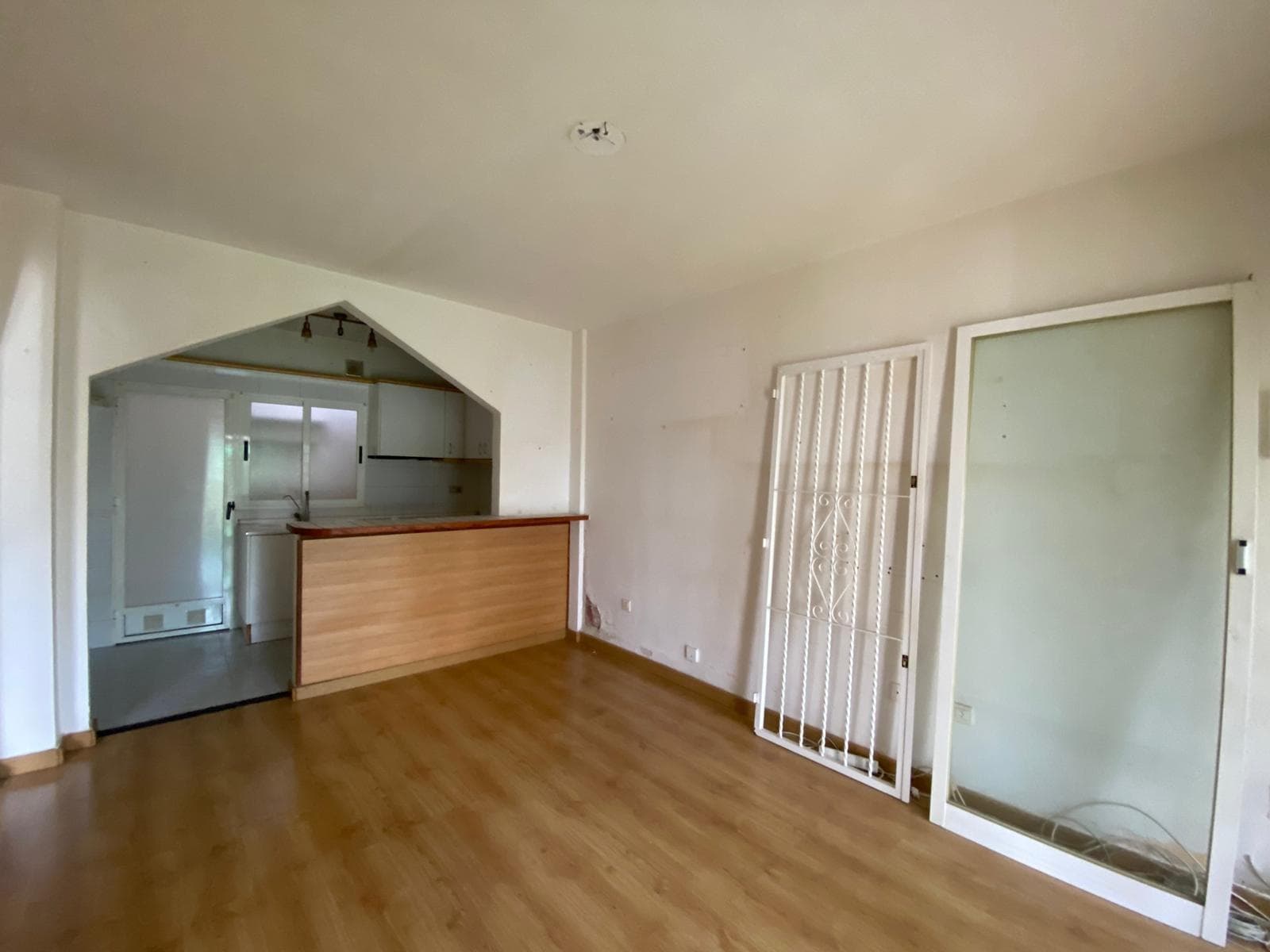 A low-rise bungalow in the La Laguna area of ​​Torrevieja, designed for those who want to live each day calmly, close to everything but with the feeling of their own personal sanctuary. From the moment you approach, you can tell it's not just any house, but a small home prepared to enjoy the climate, the sun, and quiet moments after a day at work or the beach. The entrance invites you to slow down, leave the rush behind, and focus on what's important: being comfortable, feeling at ease, and having a space that truly feels like your own. The terrace becomes the first meeting point. It's the place where you want to sit in the morning with a coffee, open your laptop, check your phone, or simply let the minutes slip by as the neighborhood slowly awakens. In the afternoon, it transforms into the perfect setting for a chat with friends, a small electric barbecue, or an informal dinner under the soft light of a typical Torrevieja sunset, with that blend of sea breeze and the scent of summer that lingers almost all year round. Here, it's easy to imagine plants, an outdoor table, warm lighting, and that feeling of "I could stay here for hours." Upon entering, the living area presents itself as a seamless space, designed for uncomplicated living. The open-plan kitchen connects directly to the living and dining area, allowing everything to happen in the same environment: cooking, chatting, watching a series, studying, or working on a laptop at the table. This type of layout makes the house seem larger, allows light to flow more freely, and fosters a more social atmosphere. Whoever is preparing a meal never feels isolated, but rather part of the conversation, the game, the moment.  The living area invites you to arrange it according to your own style: a comfortable sofa, a coffee table, perhaps a bookshelf with books, candles, and personal decorations, or a TV unit with a console and sound system. It's the space where routines accumulate: movie nights, game nights with friends, video calls with family, or relaxing afternoons after returning from the beach. All this comes with the advantage of having the kitchen just steps away, making any plan easy to put together: from a quick snack to a more elaborate meal for guests. The kitchen, being an integral part of the whole, blends seamlessly into daily life as a practical yet visually appealing space. It's designed to have everything within easy reach, so preparing breakfast or dinner is effortless. This sense of flow between cooking and being with others makes all the difference in everyday life: while finishing a dish, you can chat with whoever's on the sofa, help the kids with their homework, or check the shopping list without losing track of what's happening around you. This layout helps the home feel sociable, open, and functional. The two bedrooms allow the home to adapt to different stages and lifestyles. One can become the master bedroom, with its tranquil atmosphere, wardrobe space, and more personalized decor. It's easy to imagine a comfortable bed, soft textiles, light-filtering curtains, and a few decorative touches that transform the room into a true haven for relaxation. The second bedroom offers many possibilities: a room for guests visiting Torrevieja for a few days, a children's room, a home office, a hobby room, or even a spacious dressing room if you're looking for something more exclusive. Having a single, well-designed bathroom simplifies maintenance and makes the property especially practical for those who don't want the hassle of cleaning too many spaces.