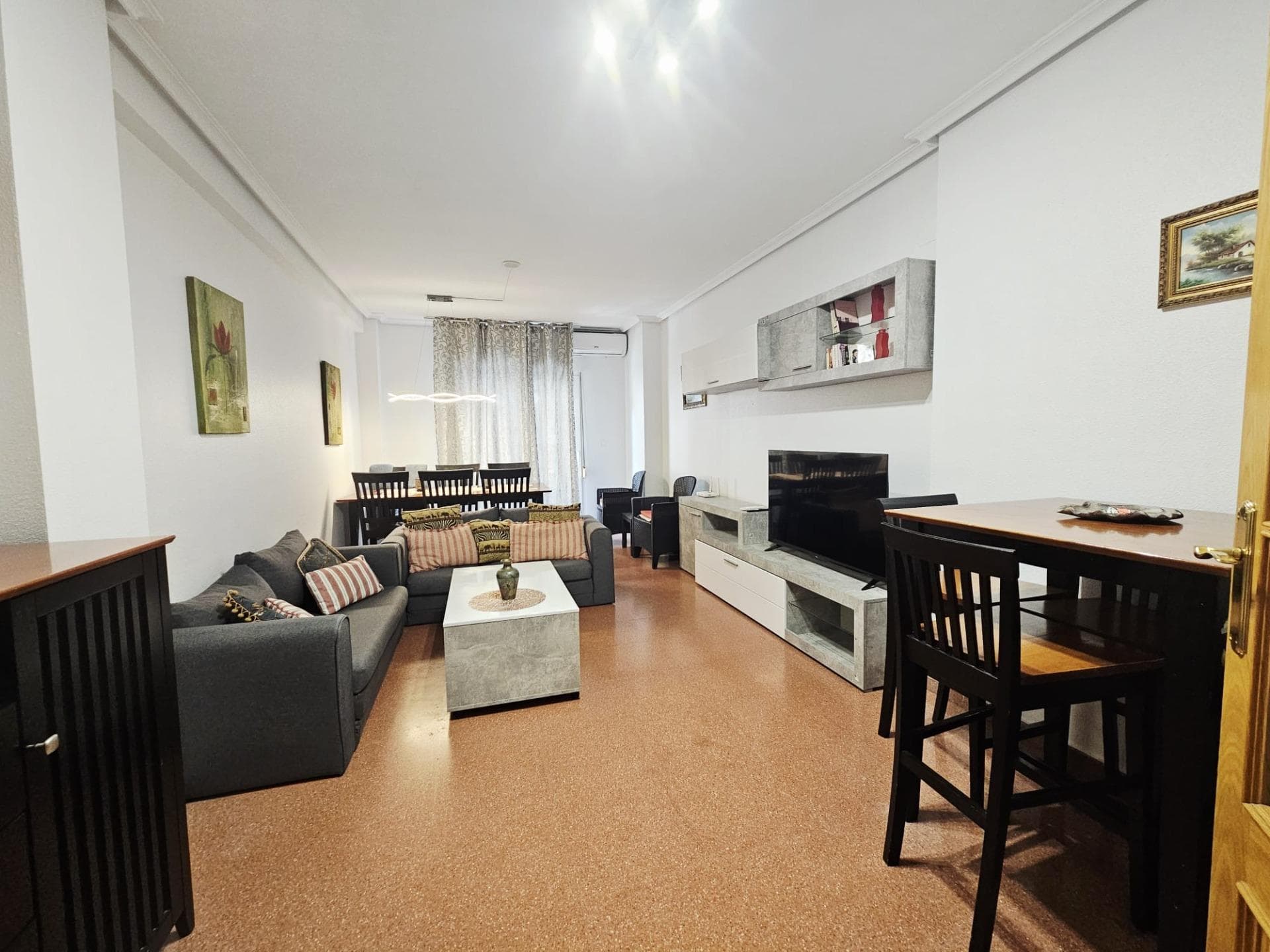 Apartment in the heart of Torrevieja's city center, in La Ermita, at 20 Zoa Street, designed for those seeking the convenience of the city combined with private spaces to enjoy the sun and Mediterranean lifestyle without complications. This home captures the vibrant essence of Torrevieja, where every day is lived with everything essential close at hand: markets, shops, bars, and the friendly, ever-present buzz of the neighborhood. It's the kind of place that invites you to linger, make spontaneous plans, and feel that your home is the perfect base from which to explore the coast and its rhythms. From the first glance, the terrace reveals itself as the open soul of the home, a space that transforms with each passing day. In the morning, it becomes the ideal spot for a leisurely breakfast, with the sun gently filtering in as you plan your day, read the newspaper, or answer emails with a steaming cup in hand. On warm afternoons in Torrevieja, when the heat invites you to pause, this is the perfect place to set up a light table, comfortable chairs, and let the hours drift by in conversation with family or friends who drop by unexpectedly. The breeze from the town center, with its blend of aromas from freshly baked bread and the nearby sea, makes this outdoor space feel alive, connected to the neighborhood without losing its own private feel. The solarium elevates this experience to another level, offering an elevated refuge where the Costa Blanca sun can be enjoyed to its fullest. Imagine entire afternoons lying down with a book, relaxing sessions with soft music, or informal gatherings where the urban skyline blends seamlessly with the clear sky. It's the place for those moments of total disconnection, where you can sunbathe, meditate, or simply watch as day gives way to night with the city center lights illuminating the landscape. In Torrevieja, where good weather is the norm, this space is used almost year-round, becoming a natural extension of the home that multiplies the possibilities for daily enjoyment. Upon entering the common area, the separate kitchen acts as a discreet yet essential hub, a dedicated space for preparing meals calmly and undisturbed. Here, daily rituals unfold: the aroma of a slow-simmering stew for family dinner, a quick check of ingredients for an impromptu weekend paella, or the organization of the weekly shopping trip in preparation for the day's hustle and bustle. Its separate location allows it to be a space for concentration when needed, yet always accessible for anyone who wants to help or chat while cooking. In the heart of La Ermita, where life moves quickly outside, this kitchen offers a welcoming contrast, a place to cook with pleasure and without haste. The living area opens up as the social heart of the house, a spacious environment where routines and plans converge. It's easy to envision a large sofa facing the television for binge-watching, a central table for shared meals, or a cozy corner with armchairs for long conversations. Natural light streaming in from the terrace illuminates everything, making the space feel bright and inviting even on cloudy days. This is where you'll find get-togethers with friends passing through the neighborhood, afternoons of playing with the kids, or even hours of remote work on your laptop—all with the advantage of being right in the heart of the city center, where a stroll is just minutes away. The three bedrooms offer complete flexibility to suit any lifestyle. The master bedroom could be your personal retreat, with space for a large bed, ample closets, and details that make it feel like a private sanctuary after a day exploring Torrevieja. The other two lend themselves to a variety of uses: bedrooms for children growing up and independent, spaces for frequent visitors, or even a bright home office for studying or running a business.