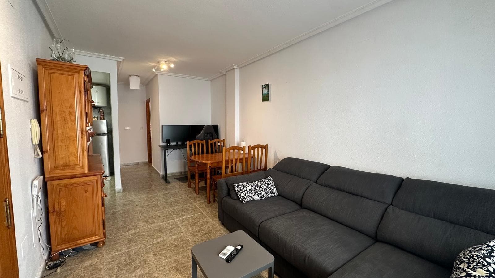 This one-bedroom, one-bathroom apartment, located in the heart of Torrevieja, is the ideal choice for those seeking a comfortable, practical, and move-in ready home, complete with everything you need from day one. Its central location allows you to fully enjoy the urban atmosphere, nearby amenities, and Mediterranean lifestyle, making it an excellent option as a primary residence, a second home, or a rental investment. Situated in one of Torrevieja's most sought-after areas, it perfectly combines the tranquility of home with proximity to the main leisure areas, shops, and points of interest. The moment you step inside, you'll feel a welcoming and well-maintained home. The fact that it's being sold furnished greatly simplifies the purchase decision, eliminating the need to worry about moving, new purchases, or long-term plans: simply move in with your suitcases and start enjoying your new surroundings. The furnishings add warmth to the ambiance and allow you to quickly imagine what daily life will be like in the home, whether you intend to use it as a personal retreat by the sea or plan to rent it out for income. This immediacy, this "ready-to-move-in" feel, is one of its greatest appeals, especially for those seeking a quick, practical, and uncomplicated solution. The separate kitchen adds significant value to an apartment of this type. Unlike typical open-plan kitchens, this one offers a separate room, allowing for comfortable cooking, keeping all utensils neatly organized, and maintaining the rest of the home free of cooking smells and noise. This layout makes the apartment feel more spacious and functional, creating a clear separation between the living and working areas. For those who enjoy cooking, this kitchen becomes a true mini-command center, where you can prepare everything from a quick morning coffee to a special dinner for friends without encroaching on the living room. The living room becomes the social heart of the home, a space to relax after a day's work, watch a movie, read quietly, or entertain guests. Its connection to the terrace enhances the room's natural light and ventilation, creating a pleasant atmosphere year-round. It's easy to imagine this living room decorated in your own style, with a comfortable sofa, a side table, some Mediterranean decorative touches, and perhaps a TV stand or a bookshelf filled with books and travel souvenirs. Although it's a one-bedroom apartment, the well-planned layout allows for a feeling of spaciousness and comfort. The terrace is undoubtedly one of the highlights of this home. This outdoor space becomes a true oasis in the city center, a place to disconnect, get some fresh air, and enjoy Torrevieja's mild climate. Here, you can place a small table and a couple of chairs to have a leisurely breakfast in the sun, work on your laptop while enjoying the breeze, or share an al fresco dinner on summer evenings. It can also be the perfect space to create a small urban garden, with potted plants, flowers, and a few decorative touches that add color and personality. Having a terrace right in the city center is a privilege that makes all the difference in everyday life. The bedroom, being separate, offers the privacy needed for true rest. It's the home's most intimate space, where you can create a relaxing and personal atmosphere with soft colors, pleasant textiles, and appropriate lighting.