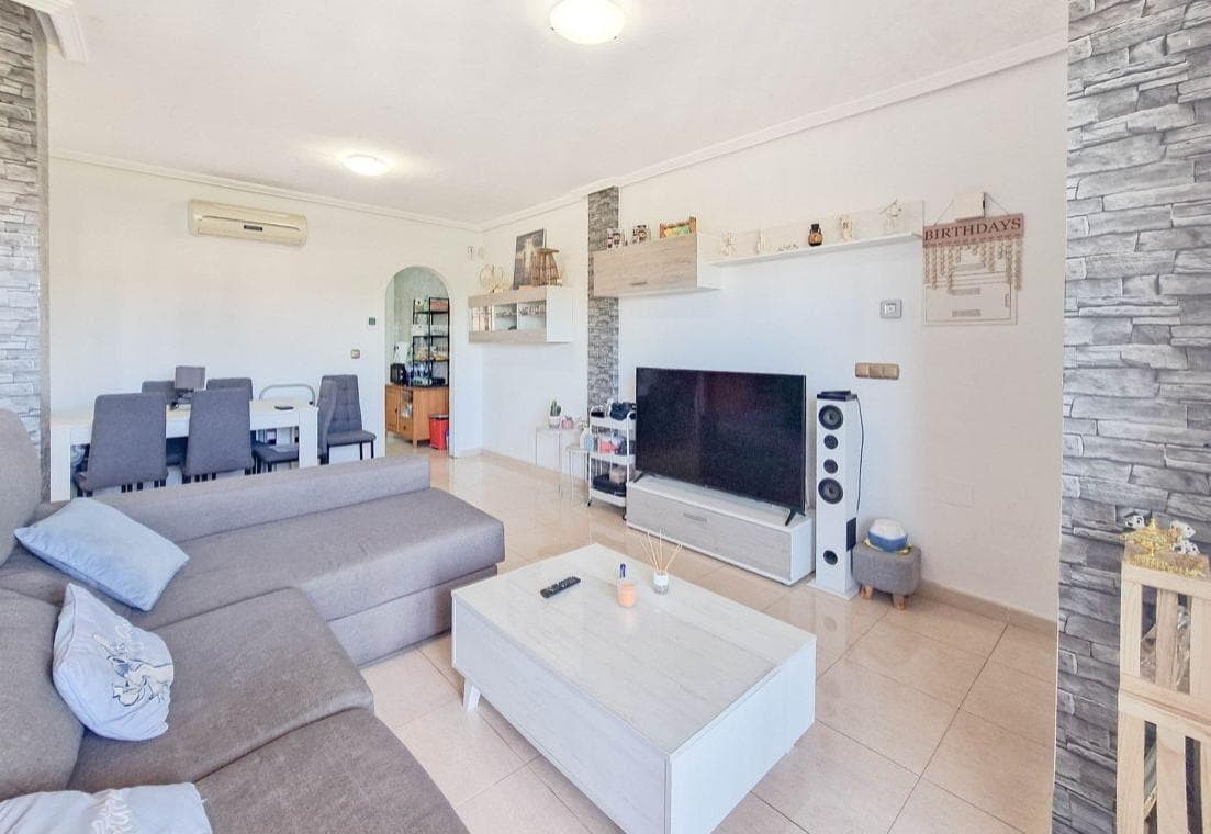 Se presenta una magnífica oportunidad de adquirir un exclusivo ático ubicado en la prestigiosa zona de Lomas de Cabo Roig, una de las áreas residenciales más demandadas de Orihuela Costa. Situado en la parte superior de la carretera nacional N-332, este enclave ofrece una combinación ideal entre tranquilidad, privacidad y excelente conexión con los principales núcleos urbanos y servicios de la zona. La ubicación de la propiedad es especialmente destacable, encontrándose a una distancia aproximada de dos kilómetros y medio del mar, lo que permite disfrutar de la cercanía de las playas sin renunciar a un entorno residencial más relajado y menos concurrido. Esta característica convierte a Lomas de Cabo Roig en una zona altamente valorada tanto por residentes permanentes como por quienes buscan una segunda vivienda en la costa mediterránea. El ático, orientado al sur, goza de una excelente luminosidad durante todo el día, beneficiándose de una óptima exposición solar que aporta calidez y bienestar a los espacios interiores. Esta orientación es especialmente apreciada en el mercado inmobiliario, ya que maximiza el aprovechamiento de la luz natural y mejora la eficiencia energética de la vivienda. En cuanto a su distribución, la propiedad cuenta con dos dormitorios, ambos con dimensiones adecuadas y pensados para ofrecer confort y funcionalidad. Estos espacios permiten tanto el descanso como la adaptación a diferentes necesidades, ya sea como dormitorios principales, habitaciones de invitados o incluso como despacho en el caso de teletrabajo. El baño completo, bien conservado y equipado, presenta una disposición práctica que responde a las exigencias del uso diario. El ático forma parte de una comunidad residencial que dispone de piscina comunitaria, un elemento que añade un importante valor añadido al inmueble. Este espacio común ofrece un entorno ideal para el ocio y la relajación, especialmente durante los meses más cálidos, permitiendo disfrutar del clima mediterráneo en un ambiente cuidado y agradable. Además de sus características interiores, el hecho de tratarse de un ático aporta un plus de exclusividad, al ofrecer mayor privacidad, mejores vistas y una sensación general de amplitud. Este tipo de propiedad es especialmente demandado por quienes valoran la tranquilidad y la independencia dentro de un entorno residencial. La zona de Lomas de Cabo Roig destaca igualmente por su proximidad a una amplia oferta de servicios, incluyendo supermercados, restaurantes, centros comerciales, instalaciones deportivas y campos de golf, lo que garantiza una excelente calidad de vida. Asimismo, su buena conexión con otras localidades cercanas y su accesibilidad convierten esta ubicación en un punto estratégico dentro de la costa alicantina. En conjunto, este ático representa una oportunidad muy atractiva tanto como residencia habitual, vivienda vacacional o inversión inmobiliaria, gracias a su ubicación privilegiada, su orientación sur, su distribución funcional y las comodidades que ofrece la comunidad en la que se integra. Se trata, en definitiva, de una propiedad que combina ubicación, confort y potencial, ideal para quienes buscan disfrutar del estilo de vida mediterráneo en un entorno exclusivo y bien consolidado.