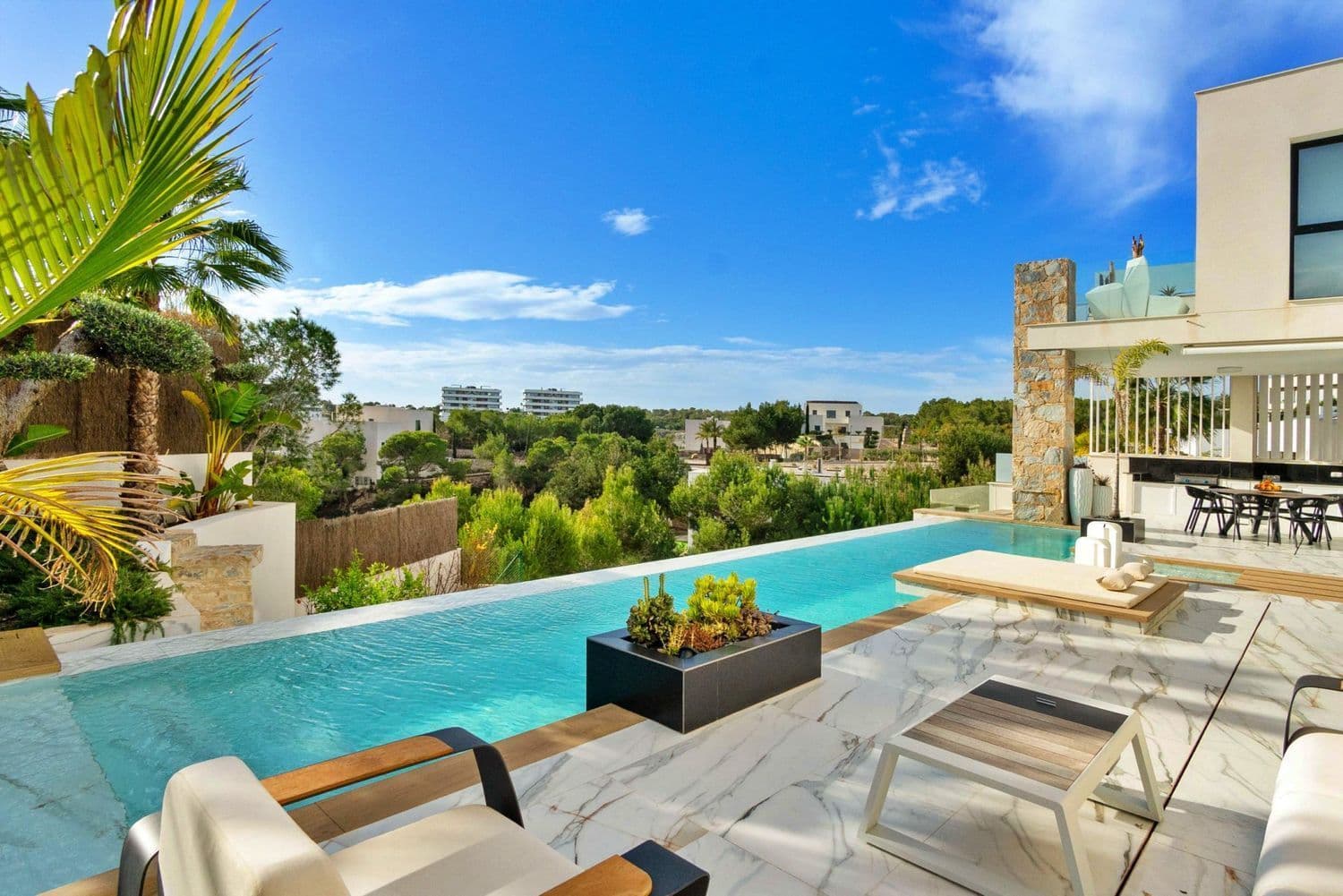 Step into pure luxury with this breathtaking 4 bedroom, 5 bathroom villa, perfectly nestled within the prestigious Las Colinas Golf & Country Club. This extraordinary residence seamlessly blends modern elegance with high-end comfort, offering an unparalleled lifestyle in one of Spain’s most exclusive locations. Ground Floor – A Grand Entrance to Luxury Upon entering, you are greeted by a stunning interior Japanese Ficus garden, setting the tone for the villa’s serene ambiance. The open-plan living and dining area is bathed in natural light, with a state-of-the-art designer kitchen featuring top-tier appliances, a connected secondary kitchen, and ample storage. Step outside to the expansive terrace, where an outdoor kitchen and dining area provide the perfect setting for entertaining. The infinity pool with a lounge and fireplace area creates an oasis of relaxation, while the meticulously designed putting green with a bunker adds a touch of leisure. This level also boasts Bedroom 1, complete with fitted wardrobes, an en-suite bathroom, and direct garden access. First Floor – Elegance & Breathtaking Views Ascend via the floating wooden staircase or private elevator to the first floor, where soaring double-height ceilings and floor-to-ceiling windows offer breathtaking panoramic views. Here, you’ll find two exquisite bedrooms: Bedroom 2: Featuring a private balcony, fitted wardrobe, a stylish workspace, and an en-suite bathroom. Master Suite: A true sanctuary with stunning golf course views, a private balcony, a luxurious en-suite with a freestanding bathtub and walk-in shower, and a spacious walk-in dressing room. From this level, you can access the rooftop terrace, where a private jacuzzi and spectacular views of the golf course and distant sea create an exclusive retreat. Lower Levels – A Private Haven & Ultimate Entertainment Guest Studio: A self-contained suite with a private bedroom, living and dining area, and en-suite bathroom with a walk-in shower. Floor-to-ceiling glass offers a direct view of the collector’s garage, making this space truly unique. Entertainment Level: The ultimate leisure area features a fully equipped kitchen and dining space, seamlessly connected to the impressive 12-car garage, a masterpiece in itself for automobile enthusiasts. A Home Beyond Compare This villa is more than just a home, it’s a statement of luxury, exclusivity, and refined living in one of Spain’s most sought-after locations. Don’t miss the opportunity to experience this architectural masterpiece firsthand. Contact us today for a private viewing. Las Colinas Golf & Country Club A World Apart! Las Colinas Golf & Country Club is one of the most prestigious resorts on the Costa Blanca! It is an exclusive and unique 330 hectare golf resort with many sports facilities including golf, padel, hiking, fitness, yoga and much more. It is A World Apart where you can enjoy a healthy Mediterranean lifestyle. With an exceptional climate and first class services, the resort has been recognised as “Spain’s and Europe’s Leading Villa Resort” by the World Travel Awards in recent years. Nestled among the hills of the Dehesa de Campoamor – on the Mediterranean coast south of Alicante – Las Colinas Golf & Country Club is a unique natural area that has been carefully preserved and where exclusive homes have been integrated into the surroundings where you can relax and enjoy the scenery. This resort, with some excellent restaurants and the Wow Beach by Las Colinas has an international reputation and is well known and sought after by celebrities. Find your dream home today by taking a look at the most beautiful and exclusive homes we have to offer!