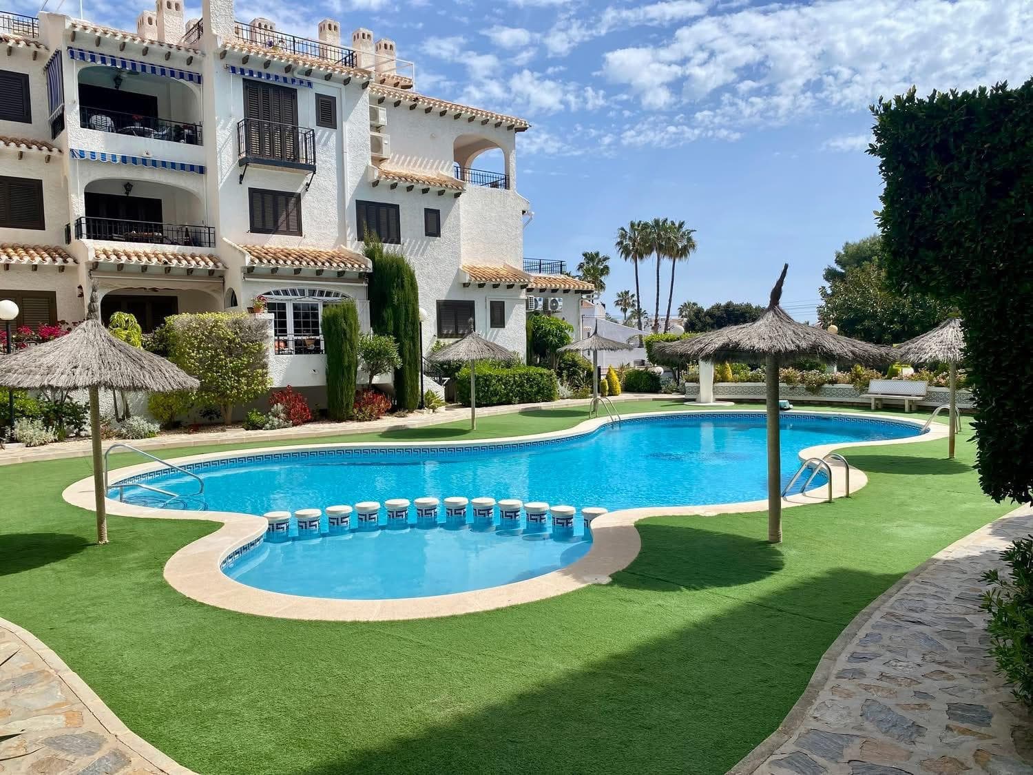 APARTAMENTO MEDITERRÁNEO CON GRAN TERRAZA, PISCINA Y VISTAS AL MAR EN CABO ROIG Descubre este encantador apartamento situado en uno de los residenciales más cuidados y demandados de Cabo Roig, a tan solo 500 metros de la playa y del mar Mediterráneo. Ubicada en un entorno tranquilo y exclusivo, esta vivienda combina luz natural, comodidad y auténtico estilo mediterráneo, siendo perfecta tanto como residencia habitual, segunda vivienda o inversión vacacional. La propiedad ofrece una distribución cómoda y muy acogedora. Al entrar, nos recibe un luminoso salón-comedor con chimenea, ideal para disfrutar durante todo el año. Desde aquí se accede a una fantástica terraza orientada al suroeste de aproximadamente 15 m², perfecta para desayunar al sol, relajarse o disfrutar de cenas al aire libre gracias al excelente clima de la Costa Blanca. Desde la entrada de la vivienda y la terraza se disfrutan agradables vistas abiertas hacia la piscina comunitaria y el Mediterráneo. La cocina americana está totalmente equipada y cuenta además con una práctica zona de lavandería independiente. La vivienda dispone de: 2 amplios dormitorios con armarios empotrados Aire acondicionado en dormitorios 1 baño completo Amplia terraza soleada Chimenea Fibra óptica instalada Vivienda totalmente amueblada y equipada Lista para entrar a vivir El residencial destaca por su cuidada arquitectura mediterránea, sus zonas ajardinadas y una magnífica piscina comunitaria con área de descanso, creando un ambiente tranquilo y familiar durante todo el año. Su excelente ubicación permite ir caminando a playas, restaurantes, cafeterías, supermercados y todos los servicios necesarios. Cabo Roig es una de las zonas más exclusivas y valoradas de Orihuela Costa, conocida por sus playas de aguas cristalinas, puerto deportivo, ambiente internacional y excelente conexión con Alicante y Murcia. Una vivienda con encanto, sol y mar, ideal para disfrutar del auténtico estilo de vida mediterráneo.