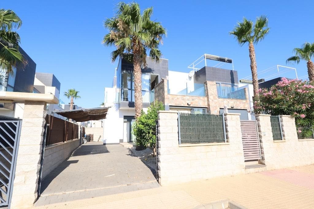 Magnificent townhouse located in the exclusive Oasis Hill residential area in Lomas de Cabo Roig. The home, spread over three levels, features two spacious bedrooms and two full bathrooms, offering comfort, natural light, and functionality.. . On the ground floor, there is a 90 m² corner garden, ideal for enjoying the outdoors, with a driveway, a bright living-dining room, a fully equipped open-plan kitchen, a bedroom, and a full bathroom.. . On the first floor is the very spacious master bedroom with an en-suite bathroom and access to a private terrace. From there, you can access the upper floor, where you will find a large solarium with a storage room and unobstructed sea views.. . The property is sold fully furnished, with air conditioning, and ready to move into.. . The residential complex has two outdoor communal pools, large garden areas, and is conveniently located close to supermarkets, restaurants, shops, and all amenities. The beaches of Cabo Roig and Campoamor are just a 3-minute drive away, and several golf courses are 5 minutes away.. . Ideal as a permanent home, second home, or investment for vacation rentals.