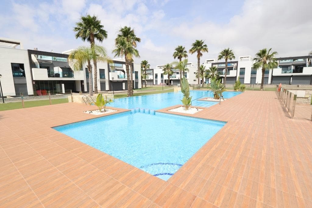 El Raso, Residencial Oasis Beach XI bungalow en planta segunda frente a la piscina comunitaria y orientación Sur dispone de  77 m2 construidos con 2 dormitorios (1 en suite), 2 baños, amplio salón comedor con cocina incorporada terraza y un solarium que ocupa la planta entera del piso con pergola. La vivienda se vende amueblada y con aire acondicionado, y cuenta con un garaje subteraneo, el residencial cuenta con 2 piscinas comunitarias, mini golf, zona infantil y zona wellness con Sauna y Jacuzzi.