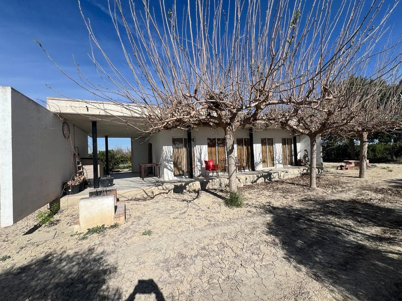 Beautiful country-style house with a modern touch. The house is cube-shaped and has large windows at the front that open onto a large outdoor terrace. Surrounded by almond, orange, and lemon trees, with a small garden full of olive and fruit trees. Ideal for long stays thanks to its Mediterranean climate, where you can enjoy the tranquility of the countryside and its biodiversity. The house has water and electricity. Just a 5-minute drive from the town of San Miguel de Salinas and 15 km from the beaches of Torrevieja and Orihuela Costa. Within a 15 km radius, you will find all amenities, as well as the Torrevieja General Hospital and the private Quirón Hospital. Ideal for lovers of tranquility and nature who also want to be within a 10-minute drive of all amenities. The house was built in 2007 on a rural plot and has running water and electricity. The sale price of the property does not include 10% tax on the sale value or purchase and sale expenses.