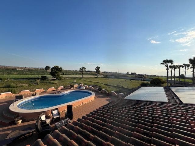 Stunning country house in Dolores, ALICANTE with 3 double bedrooms, 2 bathrooms, 2 walk-in wardrobes, lounge/diner with fireplace  open kitchen, separate preparation kitchen, study andsecond lounge with access to decking area to the garden. The villa is on a fenced plot of 6,300m with a 10 x 5m pool with large terrace surround. Ideally situated in a peaceful rural setting although close to town and only 15 mins’ drive to beaches and 35 mins to the airport of Alicante/Elche. Enjoy the superb views from the rooftop sun terrace. Mains water and electricity via solar panels with back up generator.