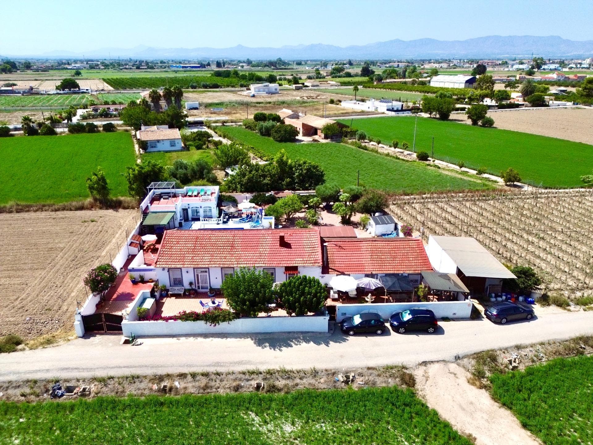 Unique 7-Bedroom, 5-Bathroom Property in Dolores Alicante. Step into a perfect harmony of timeless Mediterranean charm and contemporary luxury with this exceptional property. Nestled in a peaceful countryside setting, this country house offers the tranquillity of rural living while being just 5 minutes from the centre of Dolores, 15 minutes from the stunning beaches of Guardamar and La Marina, and 30 minutes from Alicante Airport. For golf enthusiasts, numerous championship courses can be reached within 20 minutes.. The accommodation is split between 3 self-contained units. The main residence features 5 bedrooms and 3 bathrooms, blending authentic Spanish character with bright, airy interiors and modern finishes. Expansive living areas flow seamlessly into a two separate fully equipped kitchens, perfect for family gatherings and entertaining. With two private entrances, the main house can easily be arranged into two independent living areas, making it ideal for accommodating multiple families or guests. In addition a private guest house offers 2 bedrooms and 2 bathrooms, providing privacy and comfort for visitors. In total, the property is ideal for up to three families — offering space, independence and privacy for all. Set within a fully walled plot of approximately 1,500 m², the land has been meticulously maintained and thoughtfully designed so that every area celebrates the Spanish lifestyle. From lush Mediterranean gardens and shaded terraces to multiple BBQ areas and a sparkling swimming pool, each space invites relaxation, social gatherings and enjoyment of the warm climate. The grounds also feature a variety of fruit trees, including lemon and orange trees, adding both beauty and a taste of the Mediterranean to your doorstep. This property is more than a home, it is a lifestyle where traditional elegance meets modern comfort in an unbeatable location.