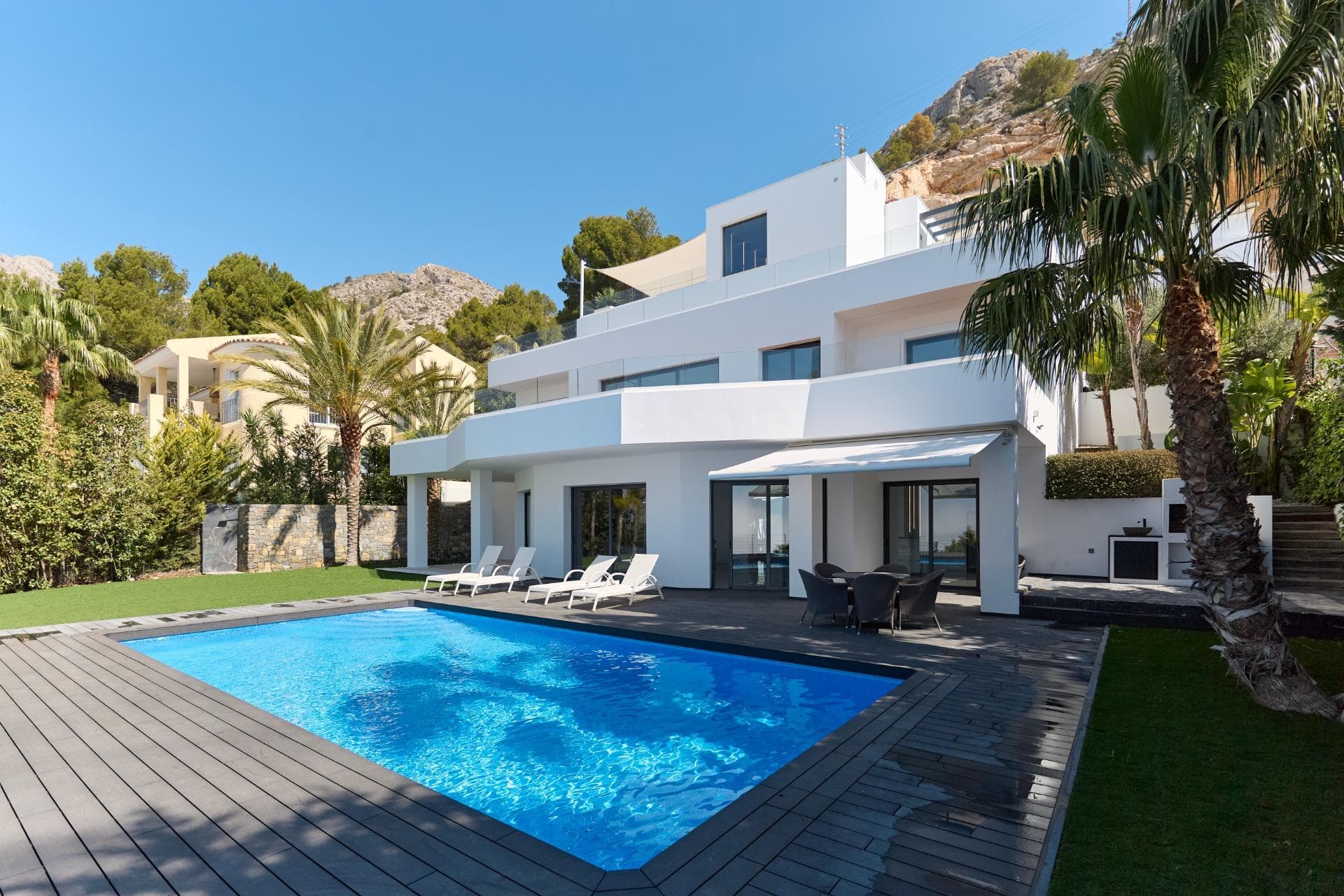 Denne elegante eiendommen ligger i et av Costa Blancas mest ettertraktede områder og kombinerer sofistikert design, komfort og banebrytende teknologi. Villaen er fordelt over tre etasjer, hvor én er dedikert til gjester – en perfekt løsning for dem som verdsetter privatliv og diskresjon. Boligen har 5 romslige soverom og 7 bad, alle utført med materialer av høy kvalitet og med stor sans for detaljer. Store vinduer gir fantastisk havutsikt og flommer rommene med naturlig lys. Det finnes utendørs parkering for 2 biler og en lukket garasje med ladestasjon for elbil. I begynnelsen av 2024 ble eiendommen fullstendig renovert, både innvendig og utvendig, inkludert oppgradering av tekniske systemer og strukturelle elementer. Villaen tilbyr fasiliteter som gulvvarme, sentral klimaanlegg, smarthussystem, elektriske låser, persienner og porter, solcellepaneler, innebygd safe, alarmsystem og heis. Uteområdet byr på romslige terrasser, en vakker hage med frukttrær, svømmebasseng med fargerik belysning og et elegant grillområde – med fantastisk utsikt over Middelhavet.