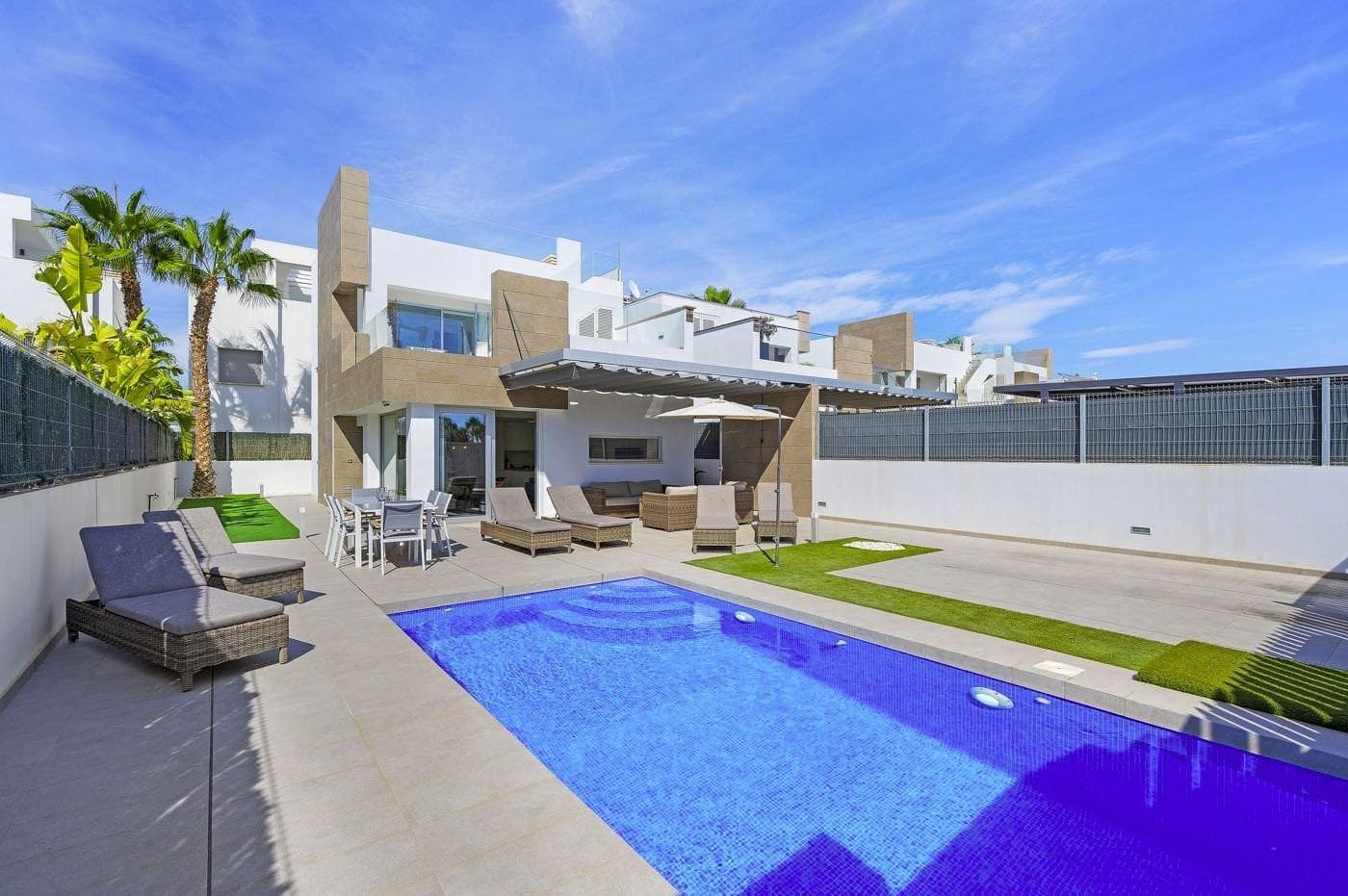 We are delighted to present this modern villa in El Raso, built in 2019. A stylish home with fantastic outdoor spaces that will make you long for sunny days and starry nights. The private garden features a heated pool, sunbathing areas, and a pergola for shade. The property is gated, and you can park your car safely on-site. Inside, you’ll find a bright, open-plan living room with large windows and a fully equipped kitchen with island dining area. The ground floor offers a spacious bedroom with ensuite bathroom (double sinks and shower), plus a guest toilet. Upstairs, there are two more large bedrooms with built-in wardrobes and a second bathroom. Two terraces and an impressive rooftop solarium provide panoramic views. The villa includes underfloor heating in bathrooms, central A/C, and electric shutters in the bedrooms. It is sold nearly fully furnished. Located in a peaceful area, just 37 km from Alicante Airport, near the Sunday market, restaurants, and a 10-minute drive to the stunning Guardamar beach.