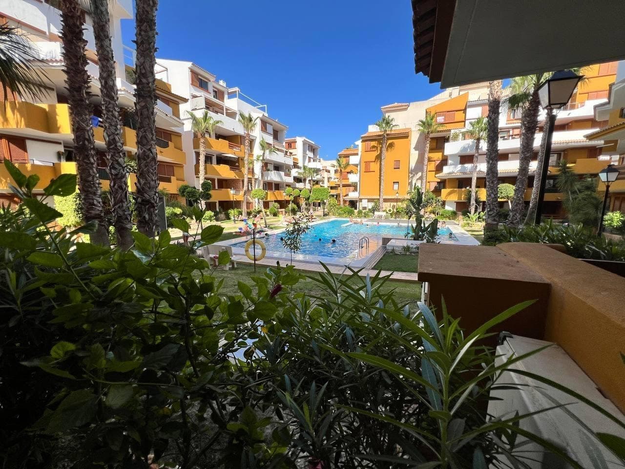 Punta Prima Recoleta, 2 bedrooms, 2 bathrooms. 350m to the beach. Bright ground-floor apartment in the exclusive LA RECOLETA development, overlooking the pool. It features 2 large bedrooms, both with built-in wardrobes, and two full bathrooms. The master bedroom has an en-suite bathroom. The living room is very spacious and bright, with a kitchenette and a utility room. The apartment faces south and receives sun in all rooms and the living room all day long in winter. The price includes a parking space and a storage room. Located just 350 meters from the beaches of Punta Prima and Cala Ferris, this apartment is ideal for those seeking tranquility and proximity to the sea. Punta Prima is a coastal development, but the La Zenia Boulevard Shopping Center, the Las Colinas, Campoamor, Las Ramblas, and Villamartín golf courses are just a few minutes away by car. There are also several sports centers where you can play padel tennis, tennis, or soccer. Within walking distance are Cala Piteras, Punta Prima Beach, and Playa Flamenca, as well as Playa de los Náufragos in Torrevieja. The development also offers excellent transport links via the AP-7 motorway and the N-332 road.