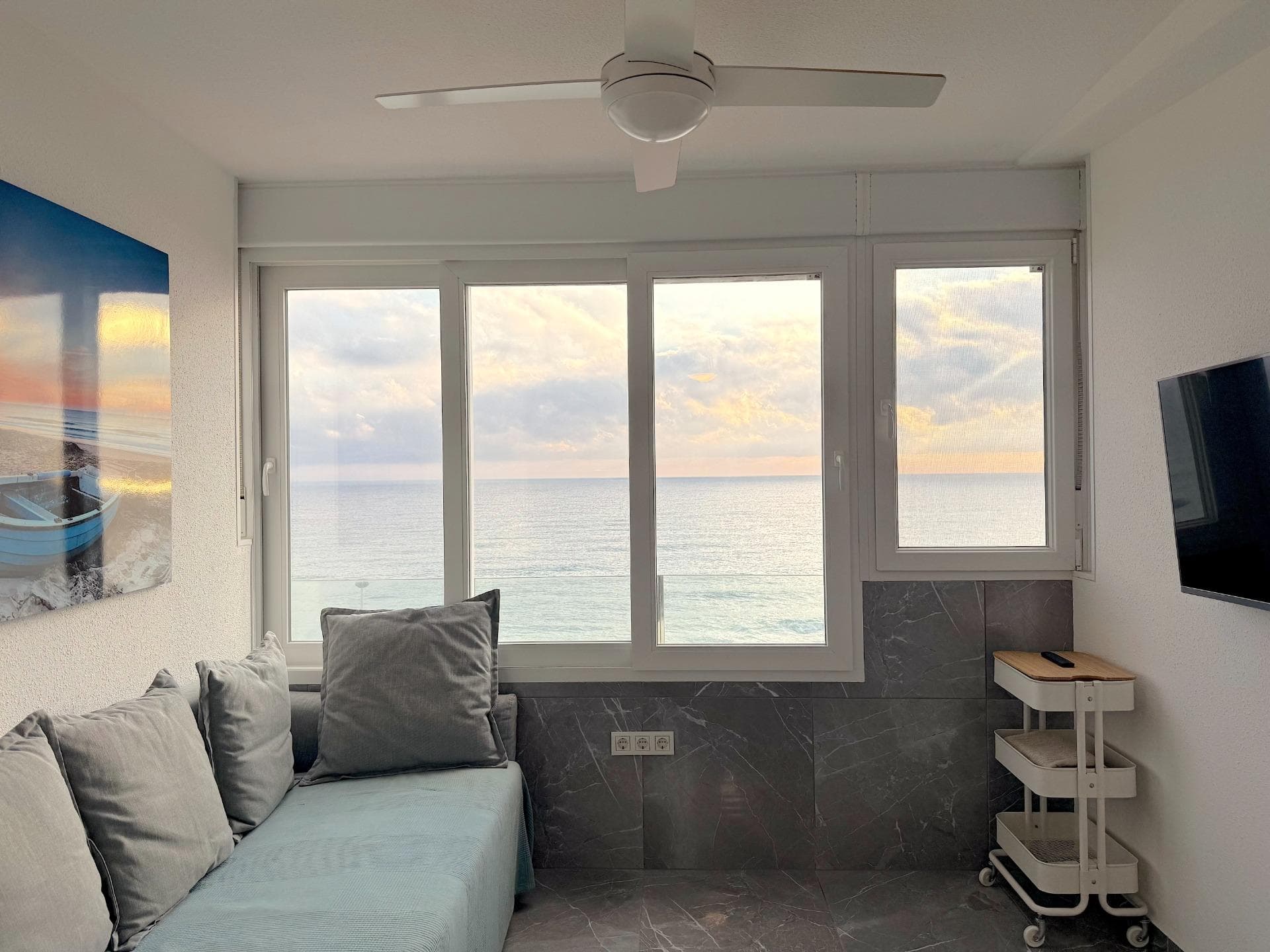 Una oportunidad poco frecuente de adquirir un apartamento completamente reformado en primera línea de mar en una de las zonas más solicitadas de Torrevieja. El complejo Miramar XII está situado en Cabo Cervera, una tranquila zona residencial con acceso directo al mar que combina tranquilidad y proximidad a todos los servicios necesarios. La principal ventaja de este apartamento es su ubicación única. El mar está a solo 10 metros, la playa de arena a unos 50 metros. No se trata de vistas laterales ni parciales, sino de vistas frontales completas al mar Mediterráneo directamente desde el salón. La orientación sur del apartamento garantiza la máxima cantidad de luz solar durante todo el día: por las mañanas hay luz y calor, y por las tardes se puede contemplar cómo el sol tiñe la superficie del mar de tonos dorados. Este tipo de apartamentos aparecen muy raramente en este complejo, ya que la mayoría están orientados hacia el interior o tienen solo vistas parciales. La orientación sur con vistas directas al mar es exactamente lo que buscan los compradores y lo que se valora en el mercado del alquiler. La zona de Cabo Cervera goza de una demanda estable tanto entre los compradores que buscan una vivienda permanente junto al mar como entre los inversores orientados al alquiler turístico. Es una zona tranquila, sin bares ruidosos ni discotecas, pero con supermercados, farmacias, restaurantes y paradas de transporte público a poca distancia a pie. Se puede llegar al centro de Torrevieja en pocos minutos en coche o utilizando el transporte público. El apartamento ha sido sometido a una reforma integral con sustitución de todas las instalaciones y materiales de acabado. No se trata de una renovación superficial ni de una reforma económica para alquilar, sino de una reconstrucción sólida, hecha a conciencia y para muchos años. Basta con mirar las fotografías para apreciar el nivel de ejecución: azulejos de calidad, fontanería sólida, detalles bien pensados. Todo está hecho de forma sólida, con materiales que no necesitarán ser sustituidos en un par de temporadas. El sistema de aire acondicionado ha sido completamente renovado: se ha instalado un nuevo aire acondicionado LG con control inverter, que proporciona una temperatura confortable tanto en el calor del verano como en los frescos meses de invierno. La cocina está totalmente equipada: se han instalado muebles nuevos, la encimera es de piedra, el fregadero de acero inoxidable está empotrado bajo la encimera, y la grifería es moderna y cromada. Junto al fregadero hay una zona de escurrido. Los enchufes de la cocina están instalados para conectar electrodomésticos: todo está pensado. El cuarto de baño ha sido completamente reformado y parece el de una obra nueva de segmento premium. Las paredes y el suelo están revestidos con azulejos de gran formato que imitan el mármol blanco, lo que amplía visualmente el espacio y da al ambiente una sensación de limpieza y luminosidad. Se ha instalado una cabina de ducha con puertas correderas de cristal y grifo termostático que permite regular con precisión la temperatura del agua. El mueble suspendido con lavabo tiene espacio suficiente para el almacenamiento, y encima hay un espejo con iluminación LED perimetral integrada. Para el suministro de agua caliente se ha instalado un calentador eléctrico Ferroli con control digital. Se trata de un equipo fiable de fabricación europea que garantiza un suministro estable de agua caliente y permite controlar el consumo de energía. El apartamento incluye un dormitorio independiente y un cuarto de baño. Hay que entender las particularidades de este tipo de complejos en la costa: los dormitorios aquí son tradicionalmente compactos, ya que la superficie habitable principal se destina a la zona de estar con salida al mar. Esta es una característica típica de la arquitectura de los apartamentos costeros, donde el énfasis está en las vistas y la proximidad al agua, no en el tamaño del dormitorio. Sin emb