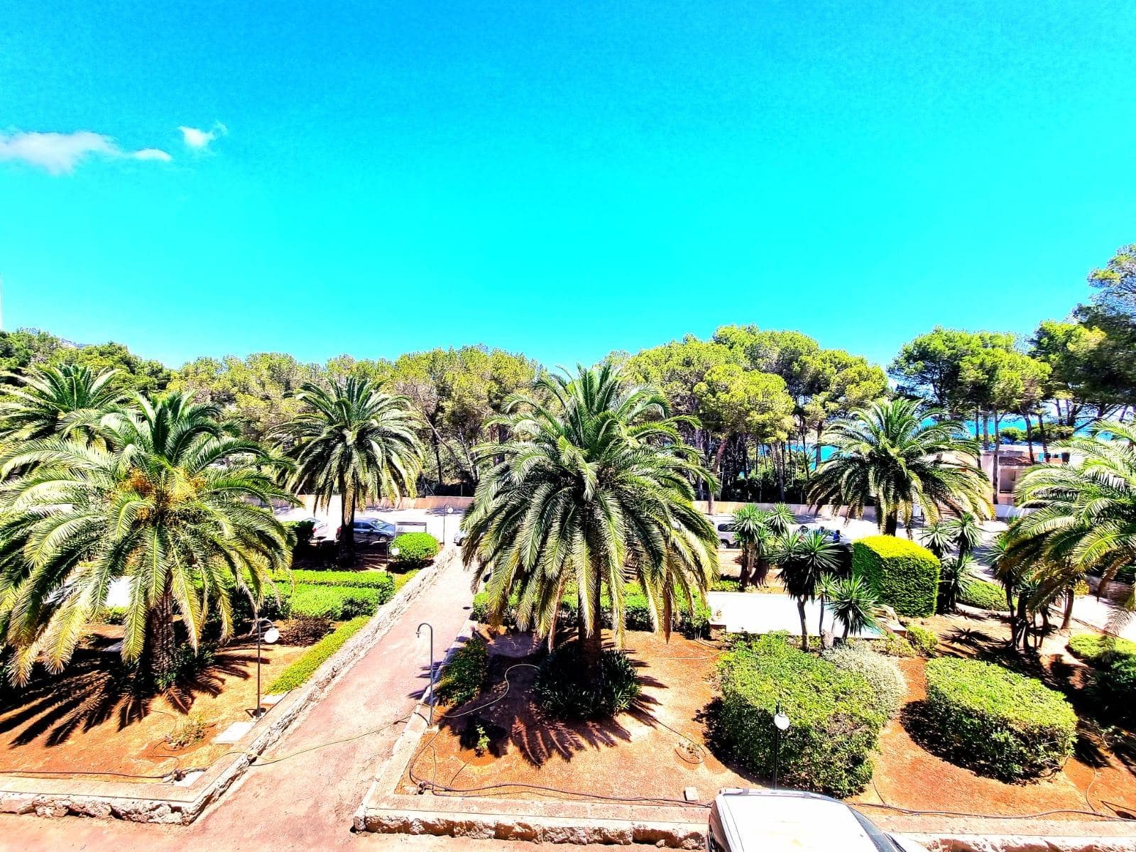 Exclusive apartment just 40 meters from the beach in Font de Sa Cala, Capdepera.. . Discover this charming apartment located in the sought-after area of Font de Sa Cala, Capdepera. A privileged setting that combines residential tranquillity with proximity to the sea – perfect as a permanent residence or for enjoying holiday stays.. This bright and welcoming apartment is situated on the second sea line, just steps from the beach, in a well-maintained residential building with elevator. The area is peaceful, exclusive, and very close to all amenities, ensuring comfort and an exceptional quality of life.. With a built area of 61 m² (50 m² usable), the property is south-facing, allowing for bright, warm, and functional living spaces throughout the day.. The highlight is the 11.42 m² terrace with partial sea and garden views – ideal for creating a stylish chill-out area or enjoying breakfast with the family while taking in the Mediterranean breeze.. There are two spacious double bedrooms with built-in wardrobes and excellent ventilation: one with a garden view, the other with direct access to the terrace. The bright living-dining room also connects to the terrace through large aluminum sliding doors, blending indoor and outdoor living beautifully.. The open-plan kitchen is fully equipped with appliances and cabinetry and includes a breakfast bar, perfect for social cooking and modern living.. There are two complete bathrooms, both with walk-in showers. Hot water is provided by an electric boiler. Though there is no central heating, the excellent orientation ensures a pleasant temperature all year round.. The property is in good condition and ready to move in, though a light renovation could enhance its full potential. The original wood-framed windows and doors with fine glass add character and charm.. The building features exclusive outdoor parking for residents and the option to rent a covered parking space for added convenience.. Community fees: €2,000 per year.. The purchase and sale transaction of this property may be completed starting from March 2026.. This is a unique opportunity to live surrounded by peace, sea, and natural beauty in one of the most enchanting corners of northeast Mallorca – where each day begins with an inspiring view.. Some images have been generated with AI to illustrate potential decor and highlight the property’s possibilities.. Important: Purchase taxes, notary, and registration costs are not included. As a construction company, we are also happy to advise you on renovation, expansion, or any project you may have in mind.