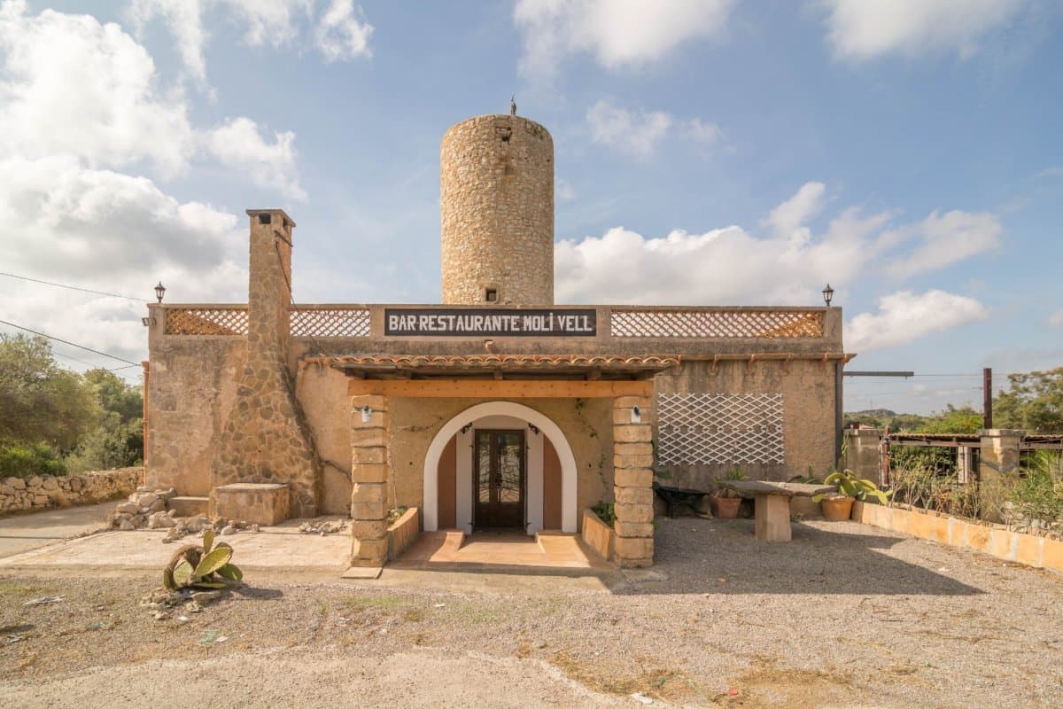 This charming commercial premises is strategically located on the edge of the road between Artà and Capdepera, in a picturesque rustic property near the Roca Viva golf course. The property stands out for its unique atmosphere, taking advantage of the structure of an old mill, and offers an ideal environment for a restaurant with charm and personality.. . Inside the restaurant we find an entrance and a hall with a welcoming access that welcomes customers. Large, spacious and bright dining room, with capacity for 32 people, designed to create a warm and pleasant atmosphere. Ideal for enjoying group meals or special events.. . Room with a bar counter with a functional and elegant area, perfect for serving clients and preparing drinks. The industrial kitchen fully furnished and equipped with modern appliances, this kitchen meets the highest standards of functionality and safety, making it easy to prepare a wide variety of dishes.. . Space for a changing room with a bathroom, designed for the comfort and privacy of the staff. A space designed for cleaning dishes and utensils, equipped with the necessary facilities to maintain hygiene and efficiency. It has two additional storage rooms, providing extra space for storage. The establishment has five bathrooms, distributed for the comfort of customers, including two bathrooms adapted for people with reduced mobility, guaranteeing accessibility for all.. . The exterior of the restaurant is adorned with several terraces, some covered, offering an ideal setting to enjoy al fresco dining and the surrounding landscape. A charming wood-burning oven and barbecue are available for lovers of outdoor cooking, adding a rustic and authentic touch to the menu. An outdoor bar that complements the restaurant's offering, ideal for serving drinks and cocktails while customers enjoy the natural environment.. . The property is sold fully equipped, ready to continue operating the restaurant without the need for additional investments. The activity license is up to date, guaranteeing legality and business continuity without setbacks.. . This establishment represents an exceptional opportunity for those seeking to establish or expand their business in a privileged location, with an infrastructure designed to offer a memorable dining experience. With its rustic charm and complete equipment, the restaurant is ready to welcome customers and become a benchmark in the area. Don't miss the opportunity to visit this property and discover its full potential!