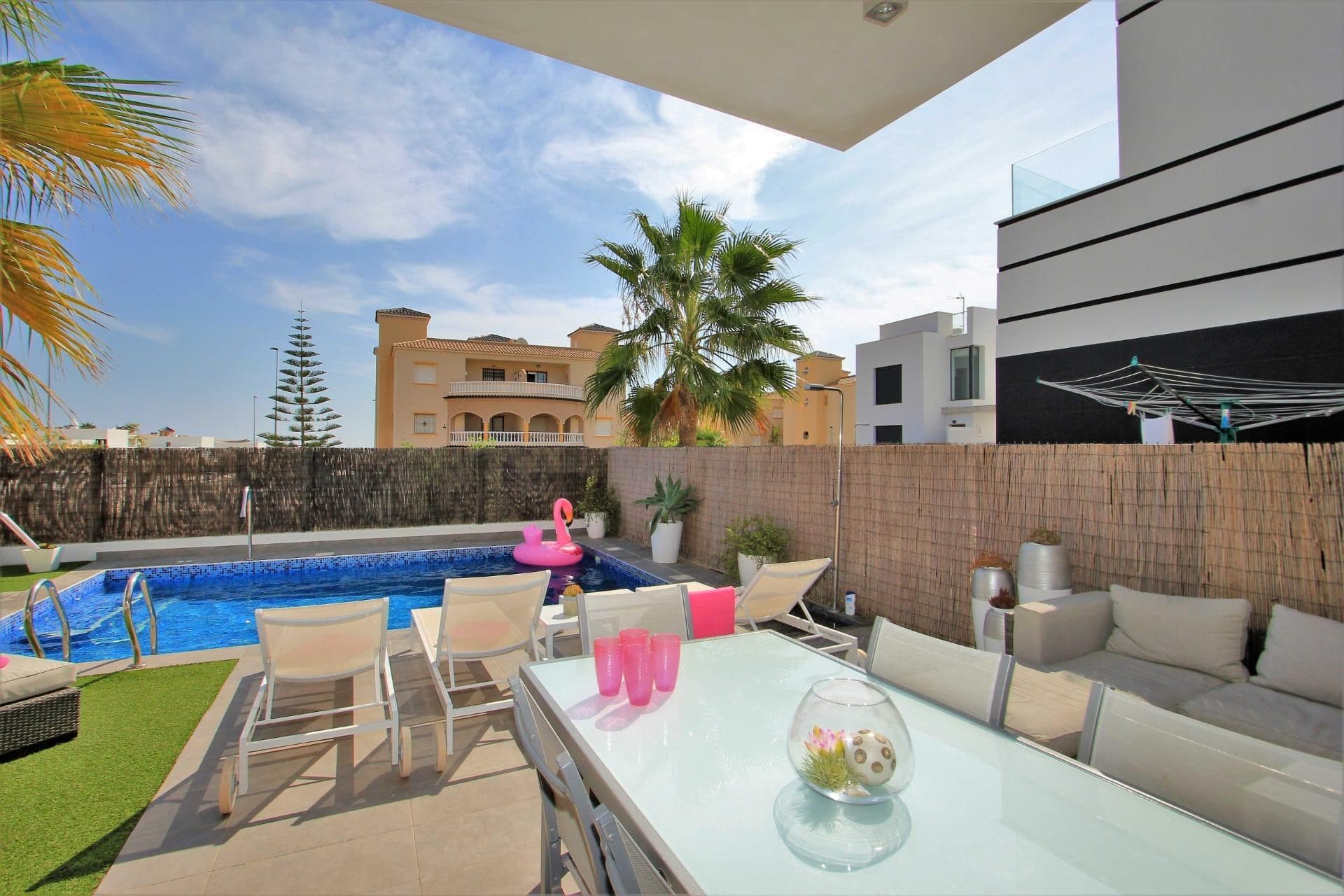 Oppdag storheten av denne imponerende luksusvillaen tilgjengelig for utleie hele året i det eksklusive området Lomas del Cabo Roig, Orihuela Costa. Med et generøst bygget areal på 130 m² og beliggende på en stor privat tomt på 340 m², tilbyr denne nesten nye eiendommen tre doble soverom og tre luksuriøse bad som kombinerer eleganse med funksjonalitet. Det fullt utstyrte kjøkkenet har moderne finish og inkluderer detaljer som innvendig snickeri i lakkert aluminium. Den sørvestvendte orienteringen sikrer rikelig med naturlig lys hele dagen, noe som ytterligere fremhever de høye takene som gir en uforglemmelig romslig følelse. Denne fantastiske boligen er komplett med eksepsjonelle funksjoner: sentralisert klimaanlegg både kaldt og varmt, romslige innebygde skap og lyse balkonger hvor du kan nyte de milde middelhavsvindene mens du beundrer klar utsikt mot havet. En vakker hage omgir boligen og tilbyr absolutt privatliv; du vil også ha din egen private basseng ideelt for å slappe av i solen eller nyte minneverdige øyeblikk med venner ved din utendørs grill. Strategisk plassert nær prestisjetunge universiteter, anerkjente skoler samt livlige kjøpesentre og sjarmerende familieparker — livet her er synonymt med ikke bare komfort, men også bekvemmelighet —. Alt dette styrket av nærliggende fasiliteter som spesialiserte lokale sykehus, noe som gjør dette hjemmet virkelig attraktivt enten for investering eller personlig nytelse.