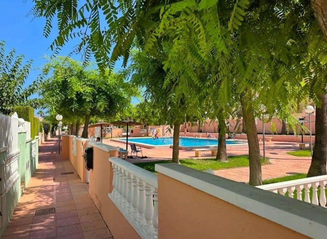 Discover this charming townhouse in the privileged area of ​​Gran Alacant, ideal for enjoying the Mediterranean lifestyle. With a constructed area of ​​60 m² and recently renovated, this property features two cozy double bedrooms that offer comfort and tranquility. The exterior stands out for its large 38 m² private terrace, perfect for relaxing or hosting outdoor gatherings. You'll also have access to a private solarium where you can enjoy the wonderful local climate. The community offers various amenities such as a communal pool, tennis court, and playground; ideal for both families and those seeking a recreational environment. Just 1 km from the Mediterranean Sea, you'll have the best beaches within reach while also enjoying proximity to public buses, shopping centers, and educational institutions. This townhouse is attractive not only for its interior features but also for its exterior: it is located within a well-maintained residential area surrounded by trees that bring fresh air to the fenced urban environment.