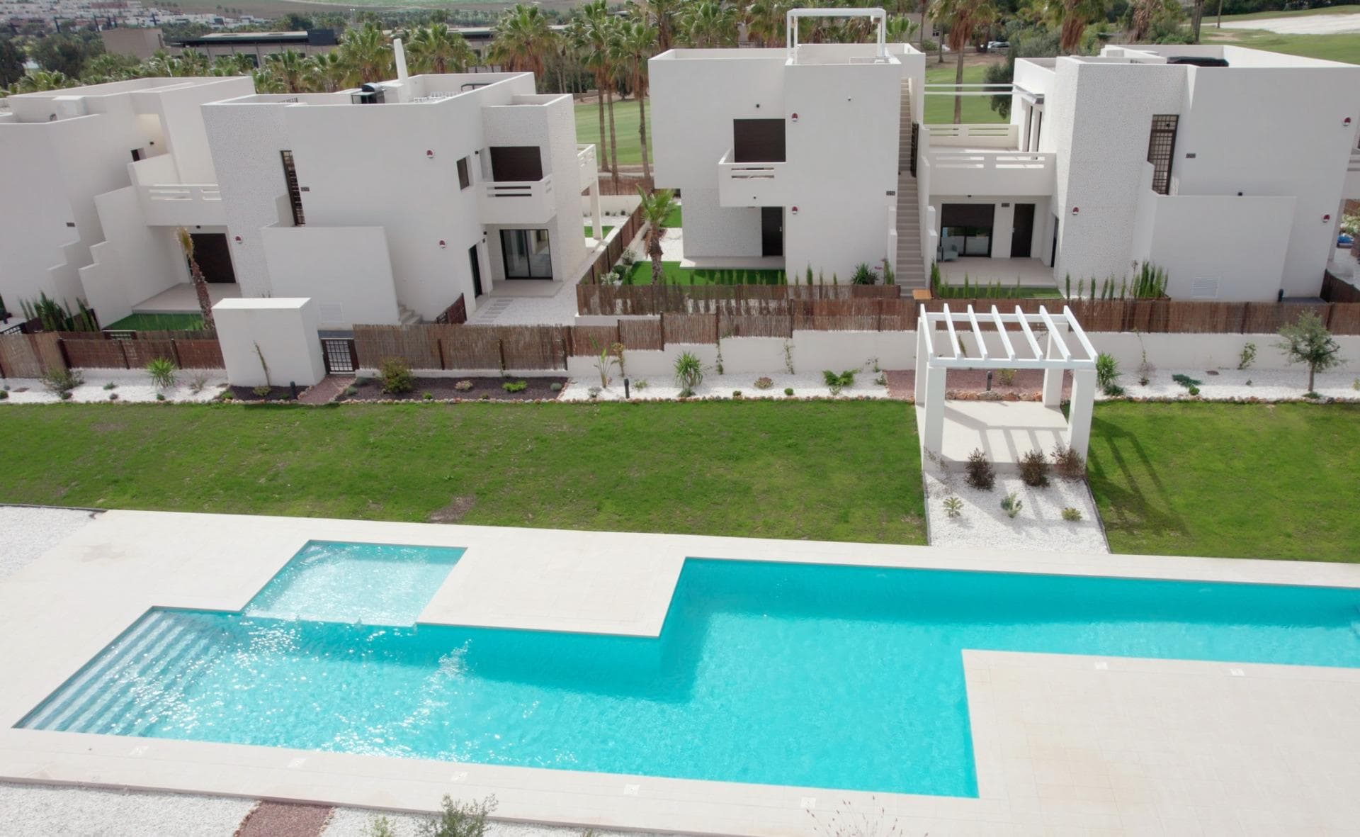 NEW BUILD RESIDENTIAL IN LA FINCA GOLF

New Build residential complex of bungalow apartments and townhouses in La Finca golf.

Modern bungalows has 2 bedrooms, 2 bathrooms, open plan kitchen integrated with 
the living area connecting the bedrooms, bathrooms and terrace.
Ground floor bungalows has terraces and gardens, top floor bungalows has terraces and solariums on the upper floor. 

Its south orientation provides natural lighting at any time of the year and natural heating from dawn to sunset, which reduces energy consumption. The opened concept properties with windows and sliding doors that allows cross ventilation and lets the light in. The properties are situated so, that the light can enter everywhere, but at the same time it offers some fresh and cozy corners.

New development takes place on an incredible plot where homes have been implemented with a careful design and large spaces to achieve maximum comfort.
Its design focuses on the comfort and well-being of its residents and combines 
contemporary style and Mediterranean character, inheriting traditional morphology with the use of stones on the façade and canopies.

Kitchens will be delivered fully furnished with a current design of high-capacity high and low furniture. The base units are in white matte lacquered laminate and the upper 
units in melamine wood with texture on the columns. Semi-hidden handle profile 
with gola* system. Countertop in work area and peninsula Quarz Compac Blanco Luna or similar.

Armoured main door with white lacquered finish on the interior leaf and brown texture on the exterior. Optical peephole and security lock.
White lacquered interior doors, with a three-strip front and rectangular stainless steel handlers.
Built-in wardrobes with white sliding doors.
Windows and sliding doors in brown aluminium carpentry with a textured finish.
Tilt-and-turn windows in bathrooms, with frosted effect glass and manual blinds.
Electric and motorized blinds, finished in brown textured aluminium. All blinds are connected to the home automation system and are synchronized to close and open, and can be operated from the App.
Special double glazing with solar control and low emissivity, to make the most of natural light and save on energy costs. Optimal aesthetic appearance, exceptional colour and minimal reflection.

Energy certification class A
Properties offers a high level of energy certification.
This is possible thanks to the thermal insulation of roofs and walls, the aluminium joinery with double glazing, and the installation of 5 solar panels by block

The homes are equipped with electrical and telecommunications outlets required by the Low Voltage Electrotechnical Regulations.
Intercom for communication between the home and the main entrance.
We include an advanced home automation system to control the motorized blinds and three light points. 
Legrand Valena Next series mechanisms that can be connected to the home automation system.
Air-conditioning pre-installation: central or split depending of the model.
Fully fitted alarm system with one sensor by room, touch panel and siren.

New development is located at La Finca Golf.
It is placed next to the first line of golf facing the 11th fairway at La Finca Golf course, one of the most emblematic complexes in the southeast of Spain and a common refuge for golf lovers.
Located just 4 minutes from Algorfa, in Costa Blanca South, this complex with indoor parking, community pool and garden areas is the perfect place for those who want to enjoy the Mediterranean lifestyle: 
proximity to the beach, golf and mountains, surrounded by tranquillity, but with access to all types of services and leisure areas.
Few minutes away from the most beautiful beaches of the southern Costa Blanca and places of exceptional beauty such as the Laguna Rosa de Torrevieja or the Dunes of Guardamar del Segura.

Its proximity and easy access to the AP-7 highway and main national roads connect complex with numerous towns on the Costa Blanca such as Orihuela, Cartagena, Elche, Murcia and Alicante.
The airports of Alicante and Murcia are less than 30 minutes driving with connections to the main European capitals.