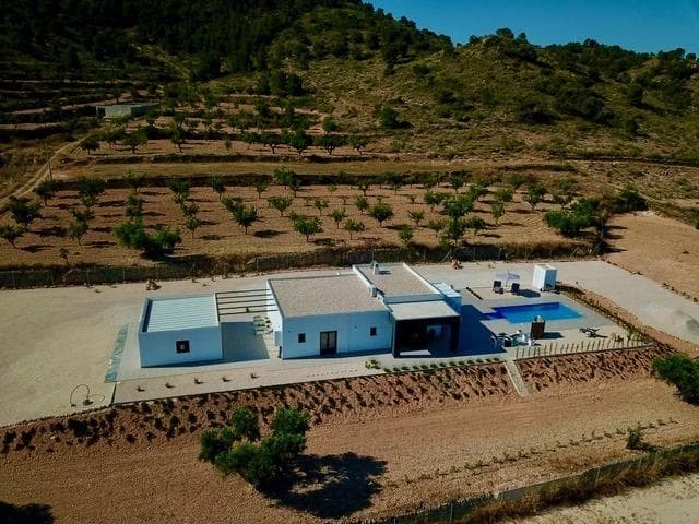 NYBYGD VILLA I ALBANILLA, MURCIA

Nybygget villa på en stor tomt i Abanilla kommune, Murcia-provinsen.

Moderne villa på ett plan bygget på en enorm tomt på 5000 m2, har 3 soverom, 2 bad, gjestetoalett, åpen kjøkkenløsning med romslig stue-spisestue, store gulv-til-tak-vinduer med mye naturlig lys, innebygde garderober.

Privat svømmebasseng. 
Garasje for 2 biler.

Ligger i den spanske kommunen Abanilla, Murcia-regionen, innenfor Sierras de Barinas, Espada &amp; Quibas; på A9-veien, som grenser til Alicante kommune i byen Algueña. Det ligger i et område med stor, naturlig skjønnhet, omgitt av vingårder som produserer lokale viner i regionen, og bare 15 minutter fra Fortuna, kjent for sine naturlige varme kilder. Det antas faktisk at Balneario de Leana er et av de eldste naturlige termalbadene i hele Spania. Det er også landskapet kjent som Lunar de Abanilla, et sted som ligger på en sekundærvei til Baños de Fortuna, fraværet av vegetasjon og den overdrevne vannerosjonen av leirjorda - badlands - et spektakulært sted å se! Dette landskapet står i dramatisk kontrast til frukthagene i Mayoha, som er rike på alle slags hagebruk og frukt. En enklave midt i naturen som ligger bare 45 minutter fra Alicante flyplass og 50 minutter fra kysten med noen av de vakreste strendene.