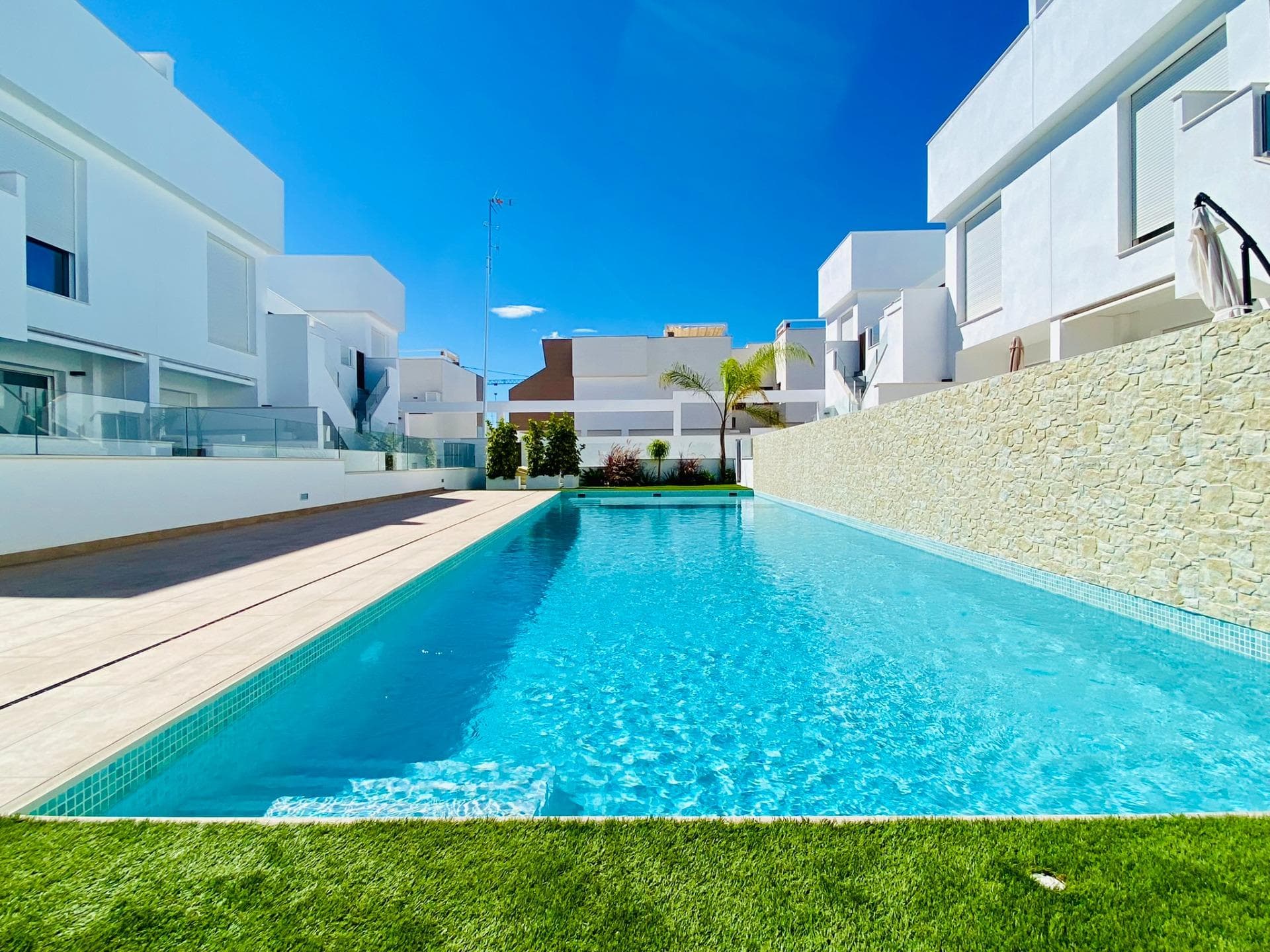 Nybygde bungalower i Pilar de la Horadada

Eksklusive moderne bungalower i Pilar de la Horadada
Dette nye boligkomplekset tilbyr 16 stilfulle bungalower i den ettertraktede byen Pilar de la Horadada, som ligger i den sørligste delen av Costa Blanca. Velg mellom leiligheter med 2 eller 3 soverom, alle med 2 bad. Leilighetene i første etasje har romslige terrasser foran og bak, med direkte tilgang til fellesbassenget og hagen, mens leilighetene i toppetasjen har et stort privat solarium på taket.

Romslig oppholdsrom med moderne funksjoner
Hver bungalow har en lys og åpen stue/spisestue og et fullt utstyrt kjøkken med store skyvedører som skaper en sømløs forbindelse mellom inne- og uterommet. Soverommene har innebygde garderober. Klimaanlegg med kanaler er installert, og komplekset har heis for enkel tilgang til de øverste etasjene. Private parkeringsplasser er også inkludert for alle enhetene.

Førsteklasses beliggenhet i Pilar de la Horadada
Pilar de la Horadada er en tradisjonell spansk by med en livlig hovedgate med supermarkeder, butikker, restauranter og barer. De vakre strendene Torre de la Horadada og Mil Palmeras ligger bare 5 minutter unna. Prosjektet ligger 40 km fra Corvera lufthavn (Murcia) og 55 km fra Alicante lufthavn, noe som gjør det til et ideelt sted for både permanent opphold og ferieopphold.