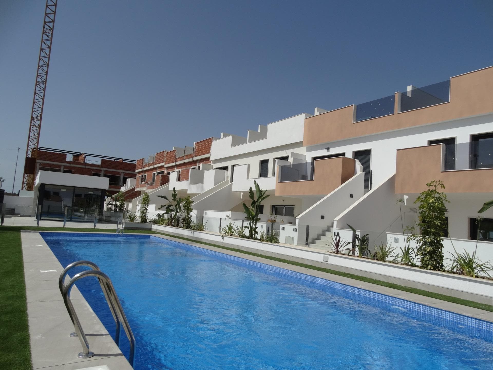 Modern New Build Bungalows for Sale in Pilar de la HoradadaMediterranean Living on the Costa Blanca SouthDiscover this exclusive new build residential complex of modern bungalows located in Pilar de la Horadada, one of the most desirable towns on the Costa Blanca South. Situated on the outskirts of the town center and within walking distance of all daily amenities, this development offers the perfect balance between tranquility, comfort and Mediterranean lifestyle.Pilar de la Horadada is a vibrant coastal town known for its welcoming atmosphere, excellent year round climate and beautiful sandy beaches such as Las Higuericas and Mil Palmeras. The area offers a fantastic selection of restaurants, cafes, sports facilities, cycling routes and golf courses, making it ideal for both permanent living and holiday escapes.Modern Bungalows with Private Garden or SolariumThis contemporary residential complex consists of 40 stylish bungalows with 2 bedrooms and 2 bathrooms, including a master bedroom with ensuite bathroom.Buyers can choose between:Ground floor apartments with private garden and parking within the plot.Top floor apartments with private solarium, storage room and designated parking space on ground floor.Many homes enjoy a south facing orientation, providing excellent natural light throughout the day, cross ventilation and pleasant views over the communal swimming pool and landscaped gardens.The properties have been designed with functional layouts and spacious interiors to maximize comfort and natural light.Quality Features and Comfortable InteriorsEach home includes modern finishes and quality specifications designed for easy Mediterranean living.Features include:Open plan kitchen fully furnished and integrated with the living and dining areaBuilt in wardrobesPrivate terraceAerothermal system for hot waterPre installation for ducted air conditioningPVC exterior carpentry with double glazingModern bathrooms with vanity units and mirrorsExclusive Communal Areas and Outdoor SpacesThe residential complex offers a beautiful communal swimming pool surrounded by landscaped green areas, creating the perfect environment to relax and enjoy the Costa Blanca sunshine all year round.The stunning beaches of Torre de la Horadada and Las Higuericas are located just 3 km away and can easily be reached by bicycle or through the pleasant pedestrian promenade connecting the town with the coast.Excellent Location and Nearby AmenitiesThis development enjoys a privileged location close to all essential services and leisure facilities.Key distances:Las Higuericas Beach: 3 kmMil Palmeras Beach: 4 kmTown center of Pilar de la Horadada: 1 kmLo Romero Golf: 6 kmDos Mares Shopping Center: 11 kmSan Pedro del Pinatar Marina: 12 kmMurcia International Airport: 40 kmAlicante Airport: 65 kmYour New Home on the Costa Blanca AwaitsWhether you are looking for a permanent residence, holiday home or investment property, these modern new build bungalows in Pilar de la Horadada offer an excellent opportunity to enjoy the Mediterranean lifestyle in a prime Costa Blanca location. Contact us today for more information or to arrange your visit.