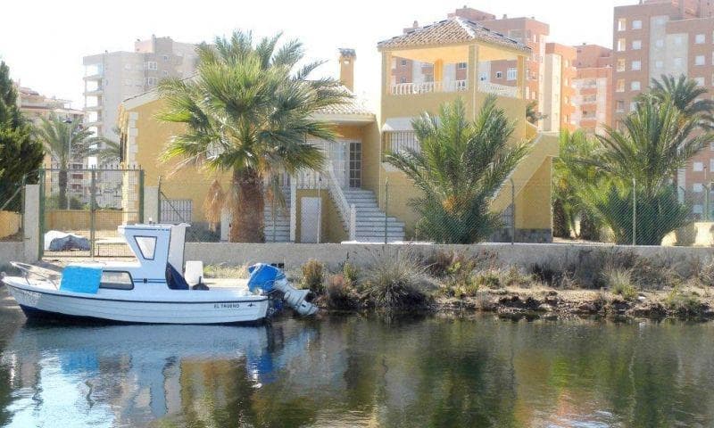 LUKSUSVILLA MED PRIVAT brygge

 Mellom to hav, Mar Menor og Middelhavet, ligger denne vakre luksusvillaen på La Manga-halvøya (Murcia), med en av de mest privilegerte utsiktene i området (og ligger noen få meter fra stranden) Denne eiendommen har en privat brygge (for en båt opp til 12 m) som gir tilgang til havet gjennom et system av brede kanaler.

 Det ligger i Veneziola-området, med umiddelbare forbindelser til de naturlige holmene, golfbanen og marinaen. Det er en ny konstruksjon med høye kvaliteter og finish typisk for en luksusbolig.

 Med et konstruert areal på 465,32 m2 på en 1 361 m2 tomt, i første etasje har den 3 veldig romslige doble soverom og 2 bad, en stor stue med peis, en separat spisestue, et romslig, uavhengig hardvedkjøkken og en stort pantry for å lagre mat, klesvask etc. Store verandaer foran og bak. Nyt 2 svært romslige terrasser og et 72m2 solarium med utsiktspunkt på toppen av bygningen med privilegert panoramautsikt over Mar Menor. Hagen er ferdig for enkelt vedlikehold og har et privat basseng. Doble glass utvendig snekker og dobbel lukking. Innebygde garderobeskap på alle soverom. Kjeller/garasje på 239m2, ideell for installasjon av treningssentre, lager, spillerom etc.

 Bak bygget er det en privat brygge som gir tilgang til sjøen gjennom et system av kanaler. Strendene er noen få meter fra huset.