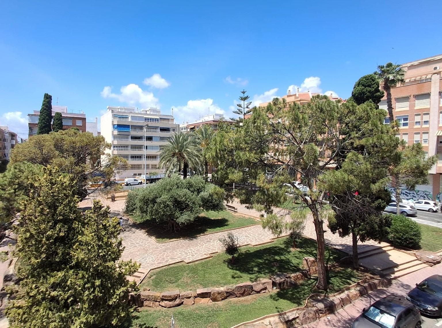 Located next to Plaza María Asunción, one of the most representative and highly valued areas in the heart of Torrevieja, this bright apartment stands out for its excellent southeast orientation, one of the most sought-after features for those who appreciate abundant natural light throughout the day. The property is situated just a five-minute walk from Playa del Cura and the seafront promenade, allowing residents to fully enjoy the Mediterranean Sea, its beaches, and all the amenities offered by the city centre. Its privileged location provides easy access to some of Torrevieja’s main thoroughfares, including Ramón Gallud Street, the town centre, and the Playa del Cura area, offering the perfect combination of tranquillity, comfort, and urban lifestyle. One of the property's greatest highlights is its open views over the park, which can be enjoyed from every room. The unobstructed outlook, the absence of buildings directly in front of the windows, and the southeast orientation create an exceptionally bright and welcoming atmosphere throughout the year. The apartment offers 63 m² of usable living space and has been completely renovated. An innovative stretch ceiling system has been installed, providing a modern appearance, resistance to humidity, easy maintenance, and the possibility of integrating lighting and ventilation systems. The electrical and plumbing installations have also been fully renewed. Additional features include underfloor heating in the bathroom and high-quality waterproof flooring throughout the living-dining area, kitchen, and bedrooms, offering comfort, durability, and contemporary style. The layout has been carefully designed to maximise the available space. Upon entering the property, there is a spacious bathroom equipped with a walk-in shower, glass screen, and underfloor heating. This leads to a bright open-plan living and dining area with large windows that flood the space with natural light and connect seamlessly to a modern integrated kitchen, both enjoying pleasant views of the park. The sleeping area consists of two bedrooms. The first bedroom is of medium size, comfortable and functional, featuring a wardrobe and views of the surrounding greenery. The master bedroom stands out for its generous dimensions, built-in wardrobe, and beautiful park views, creating a particularly peaceful and relaxing environment. The apartment is located on the third floor of a five-storey building with a lift, providing convenience for families with children as well as for those seeking comfortable and barrier-free access. This property represents an excellent opportunity for buyers looking for a move-in-ready home in a prime location, surrounded by all essential services and just a few minutes from the beach. The park views, natural light, comprehensive renovation, and proximity to the sea make this apartment an ideal choice as a permanent residence, holiday home, or investment property on the Costa Blanca.