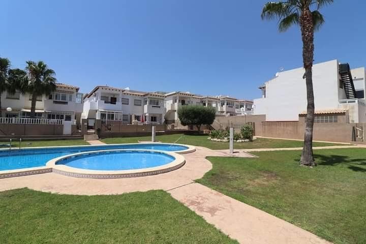 Discover this magnificent property located in an exclusive gated community, just 1,300 meters from Punta Prima beach — an ideal setting to enjoy the sun, tranquility, and sea all year round. This top-floor bungalow offers a comfortable and functional layout: two spacious double bedrooms, a full bathroom, and a bright living-dining room with access to a beautiful terrace, perfect for relaxing or enjoying outdoor dining. The independent kitchen is fully equipped, ideal for those who love cooking with space and comfort. In addition, this property features a private 26m² solarium, where you can sunbathe, host gatherings with friends, or simply enjoy the views and the Mediterranean breeze. The complex offers a communal swimming pool surrounded by green areas, providing a pleasant and safe environment for the whole family. 📍 Privileged location, close to services, restaurants, supermarkets, and public transport, and just minutes from the best beaches of the Costa Blanca. Don’t miss the opportunity to own your home or holiday retreat in one of the most sought-after areas of Orihuela Costa.