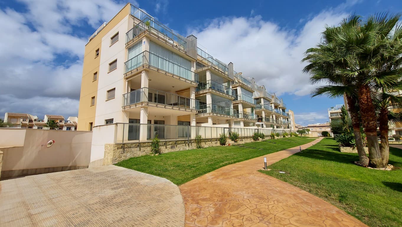 New in the offer we present to you: A gem of the top shelf

This Beautiful groundfloor apartment with a gigantic terrace that is partly covered is located in Villamartin, Orihuela-Costa. This apartment has never been lived in and is located in the well-known Villa Martin Gardens 1 Resort. Inside the apartment looks brand new!

The apartment in Villa Martin has 3 bedrooms. 1 master bedroom with en-suite bathroom including underfloor heating and 2 very spacious guest rooms.

The large and spacious living room gives a pleasant feeling and is visible from the half-open American kitchen.

Whether you like to cook or not... A large kitchen with many cupboards and equipped with all appliances is always an added value. If you walk through the kitchen you have a separate laundry room.

At the front of the living space you also have a spacious front terrace that is fully south-facing and of course with phenomenal views over the communal gardens.

The terrace is partly covered and can be closed with Glass screens that generate extra living space. From the terrace you have direct access to the amazing garden with 3 pools and one is even heated!

Great extras of this property AND included in the price:

- South facing- Underfloor heating in the en-suite bathroom

- A lot of storage space due to the built-in wardrobes

- 3 Swimming pools, 1 of which is heated, jacuzzi, and children's pool

- Outdoor fitness and petanque court

- Underground private parking space + large closed storage room

- Immediately ready to live in

Within walking distance of all facilities, shops, bars, restaurants, etc.

Close to several Golf clubs, La Zenia Boulevard, and the beautiful white sandy beaches that Orihuela-Costa has to offer.

Turnkey homes are virtually nowhere to be found in beautiful Orihuela-Costa. So don't miss this unique opportunity!

Contact us for viewings and more information!
